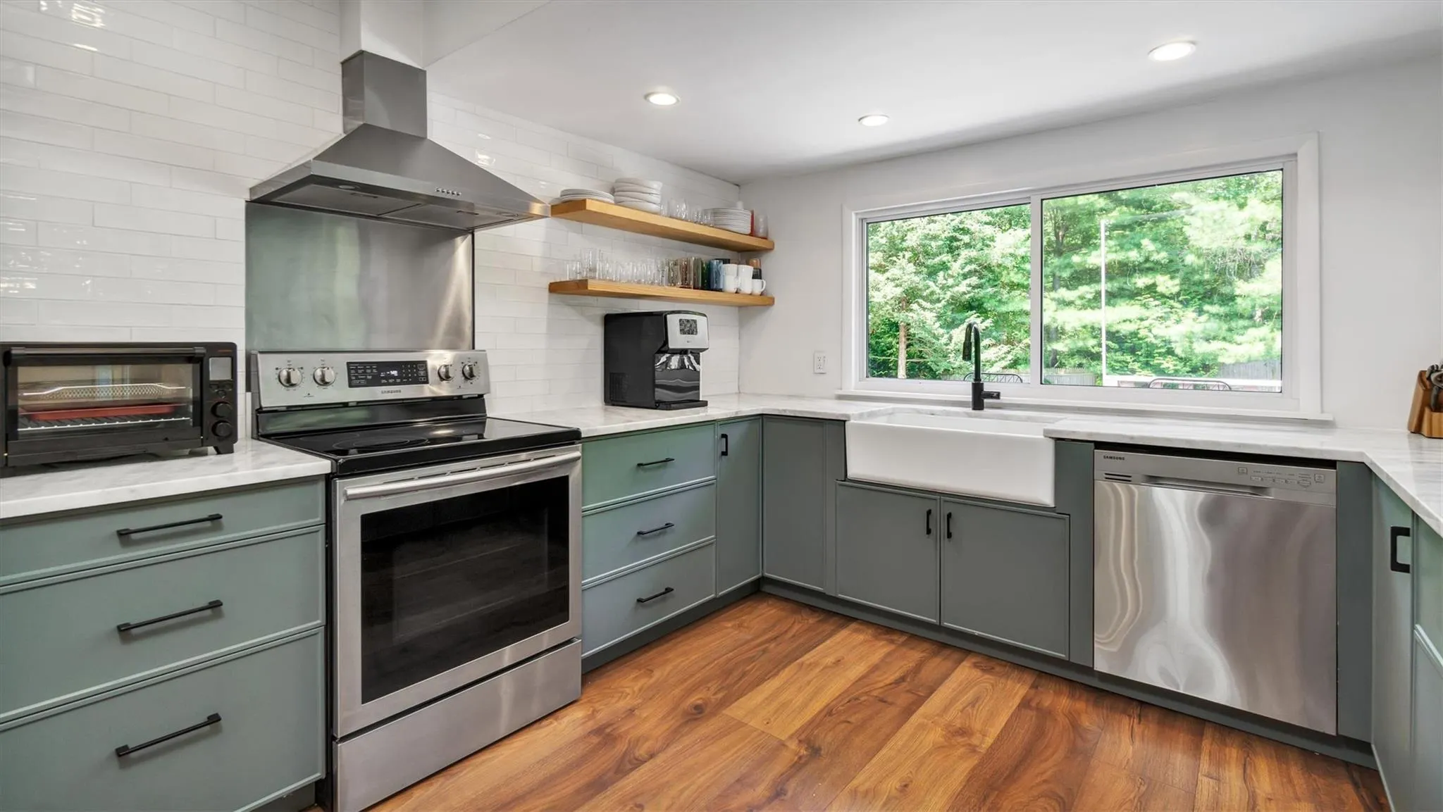 Kitchen with appliances with stainless steel finishes, a sink, wall chimney range hood. Kitchen with appliances with stainless steel finishes, a sink, wall chimney range hood.
