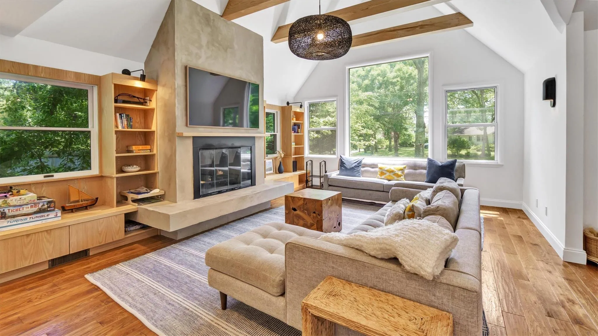 Living area featuring high ceiling, light wood finished floors and fireplace. Living area featuring high ceiling, light wood finished floors and fireplace.
