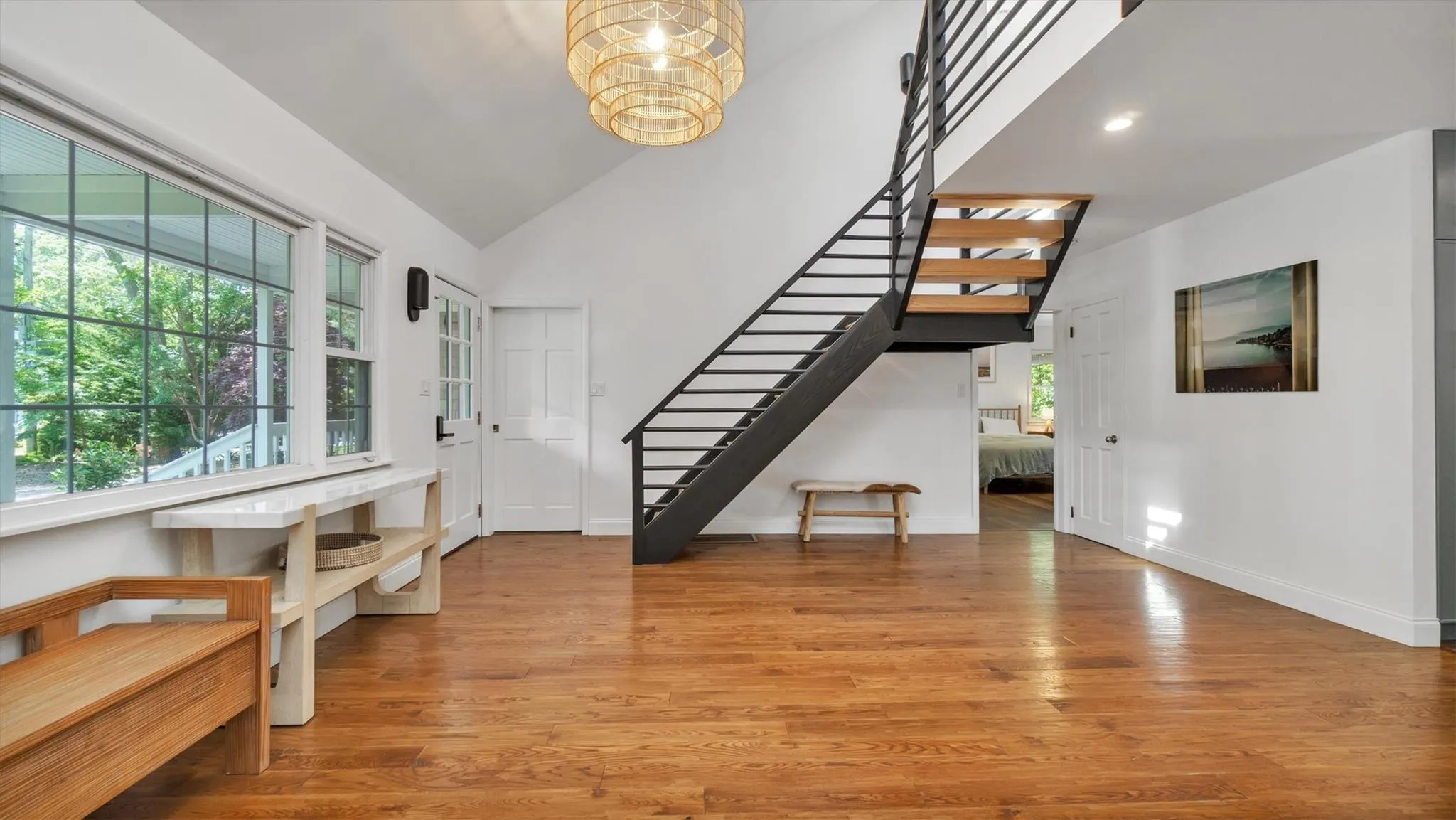 Foyer entrance featuring stairs, wood finished floors, a chandelier, and high ceiling. Foyer entrance featuring stairs, wood finished floors, a chandelier, and high ceiling.