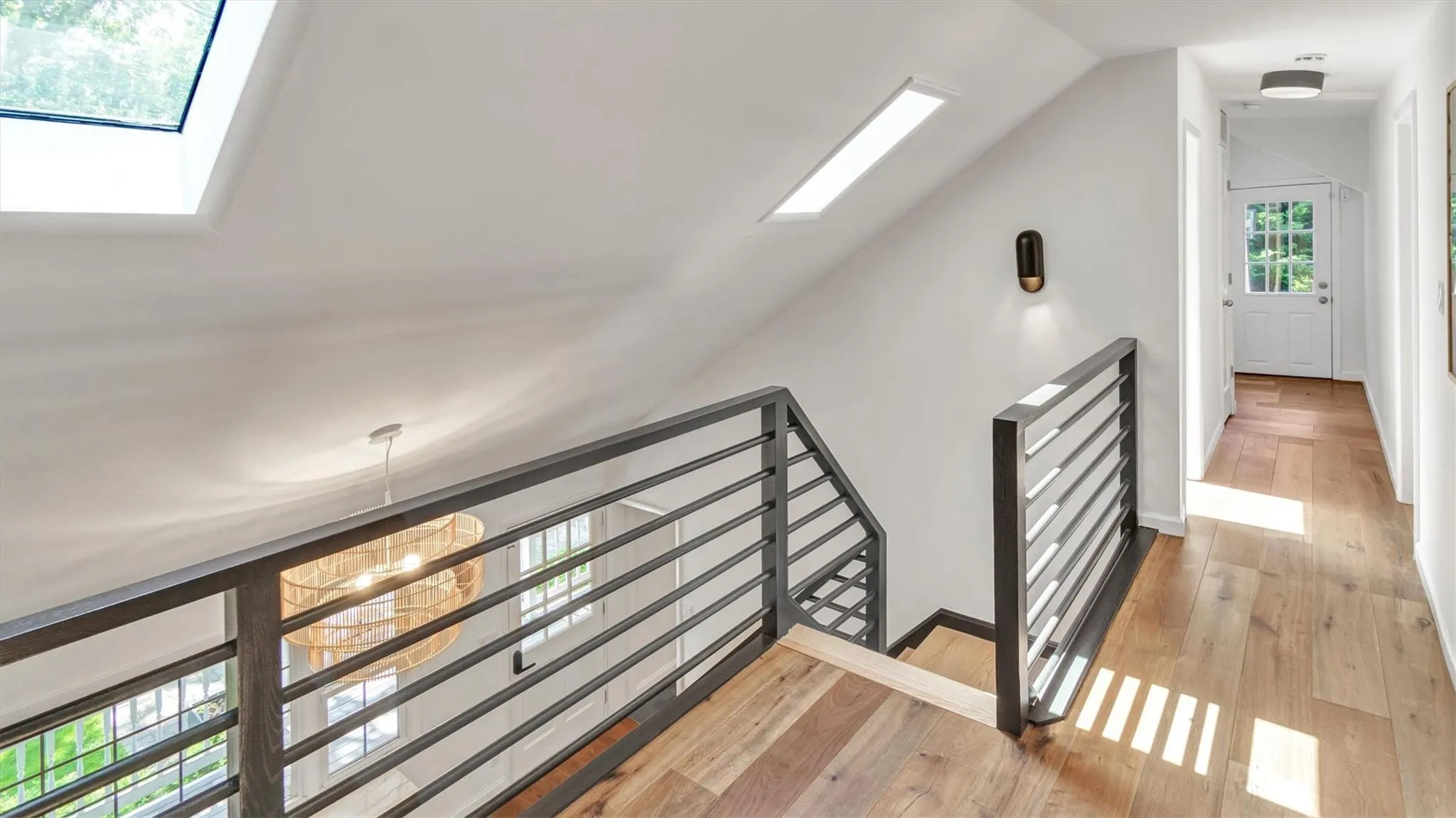 Stairway featuring a skylight, lofted ceiling, and hardwood / wood-style floors. Stairway featuring a skylight, lofted ceiling, and hardwood / wood-style floors.