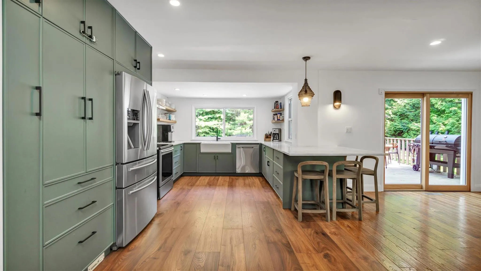 Kitchen featuring green cabinets, appliances with stainless steel finishes, a healthy amount of natural light, and recessed lighting. Kitchen featuring green cabinets, appliances with stainless steel finishes, a healthy amount of natural light, and recessed lighting.