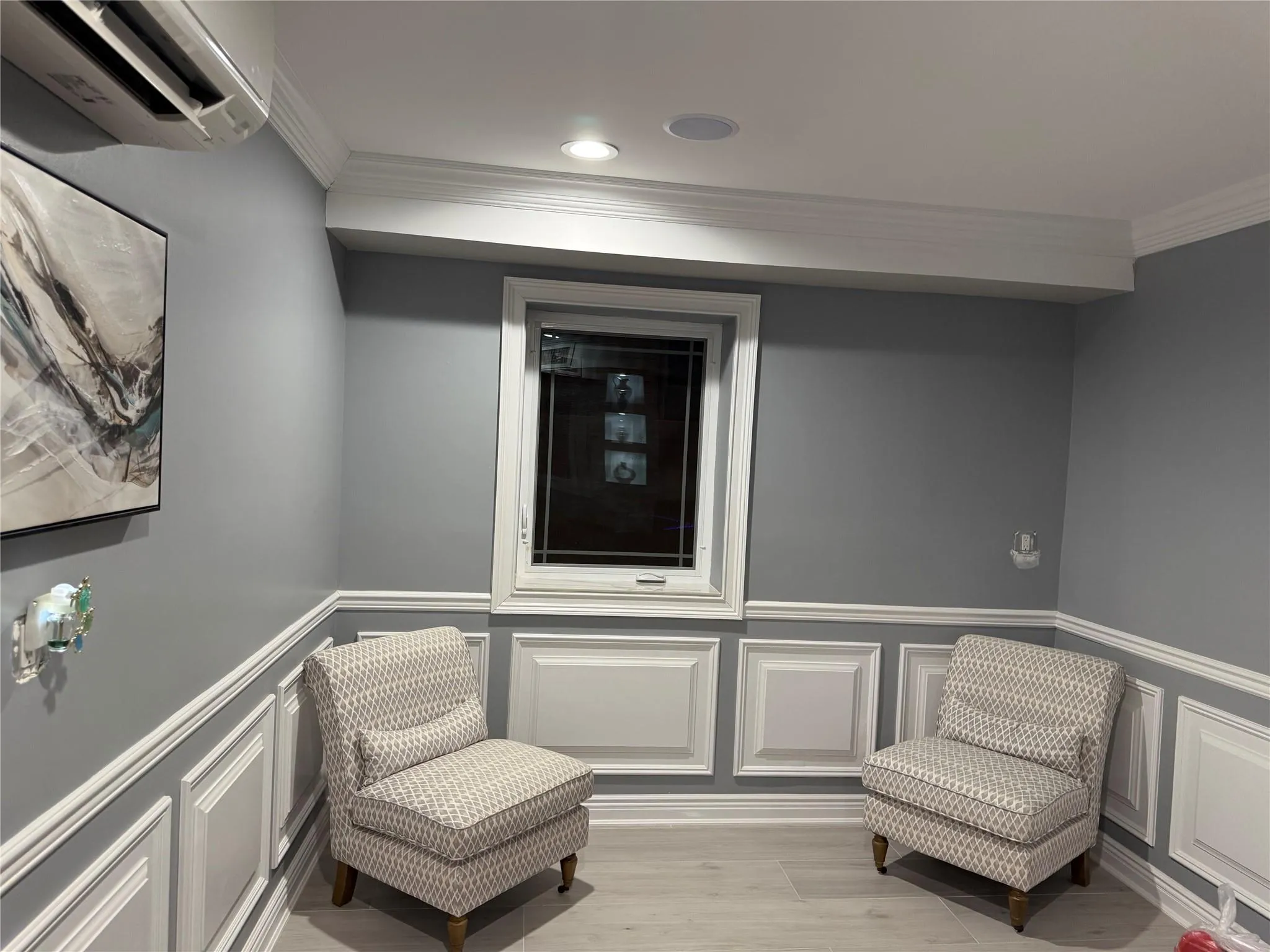 Living area featuring a wall unit AC, ornamental molding, and light hardwood / wood-style floors Living area featuring a wall unit AC, ornamental molding, and light hardwood / wood-style floors