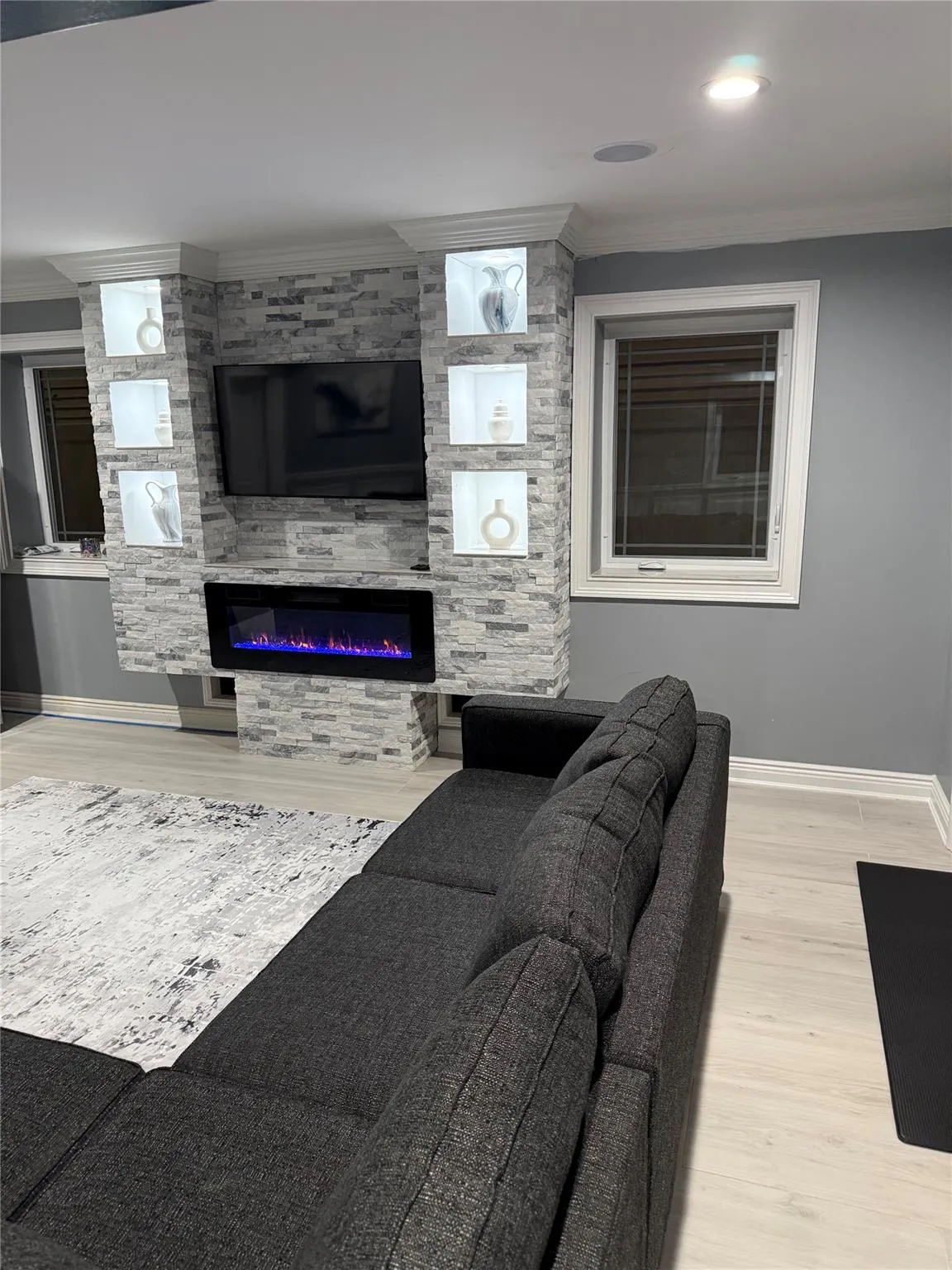 Living room with a large fireplace and hardwood / wood-style flooring Living room with a large fireplace and hardwood / wood-style flooring