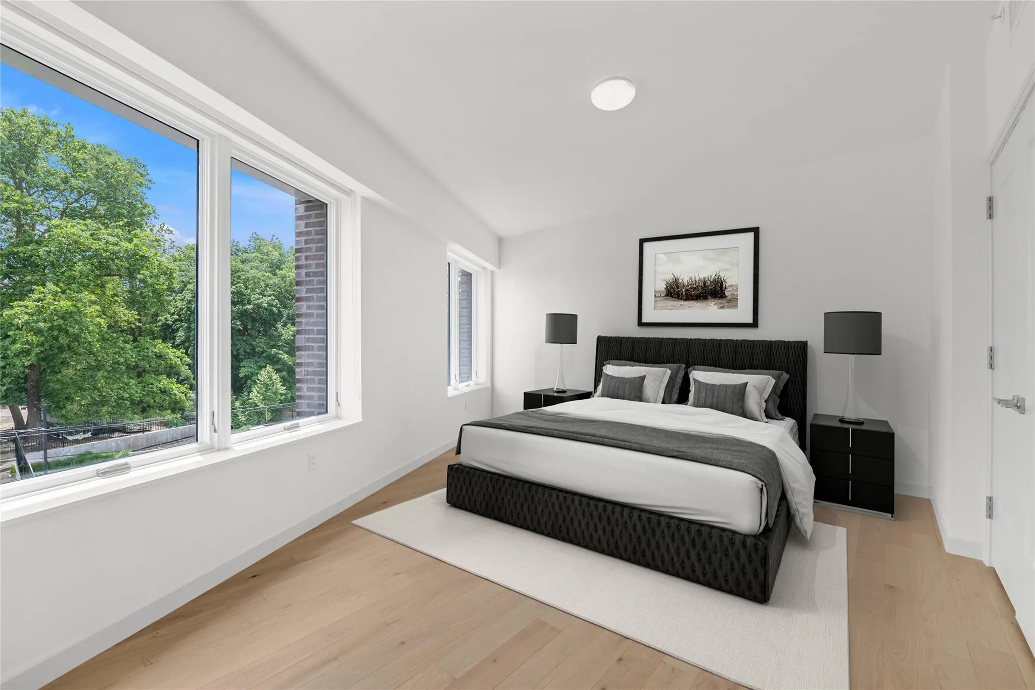 Bedroom featuring vaulted ceiling and light wood-style floors Bedroom featuring vaulted ceiling and light wood-style floors