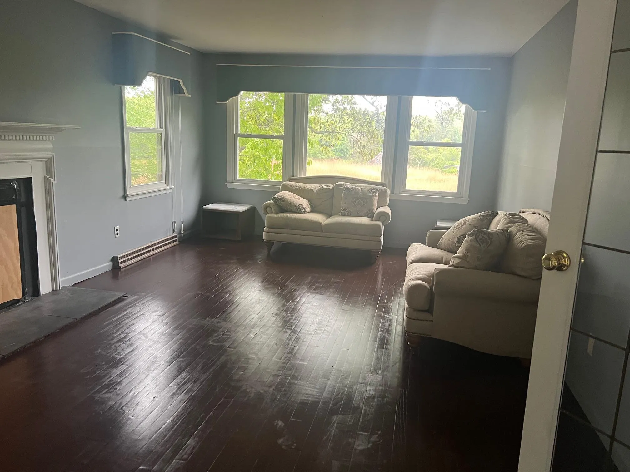 Living area featuring wood finished floors and a high end fireplace Living area featuring wood finished floors and a high end fireplace