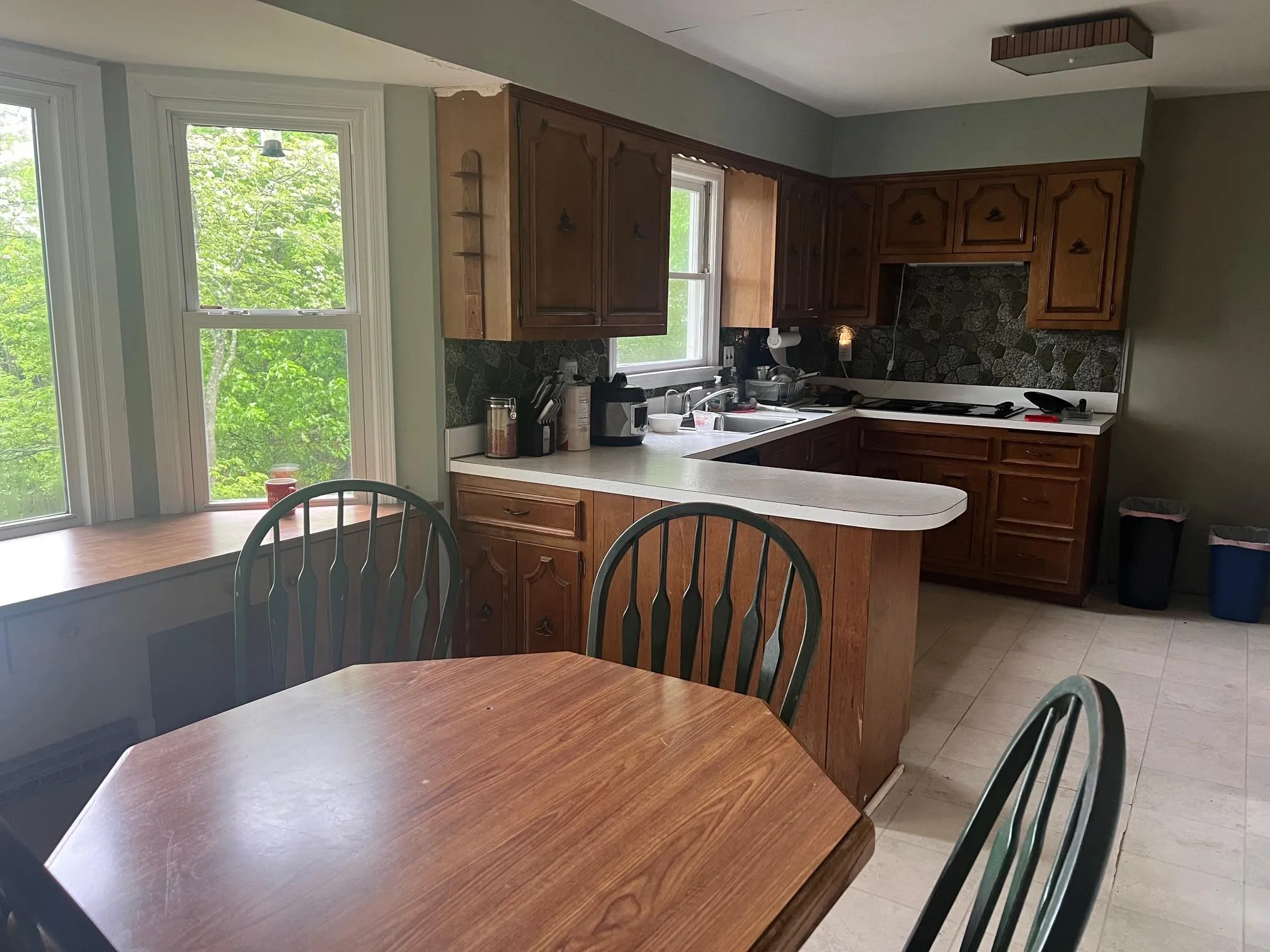 Kitchen featuring tasteful backsplash, light countertops, a peninsula, and a sink Kitchen featuring tasteful backsplash, light countertops, a peninsula, and a sink