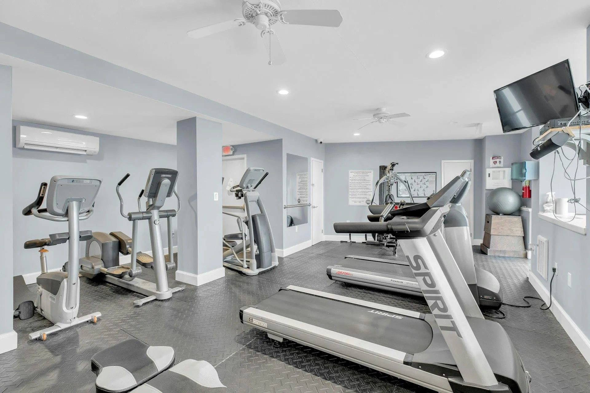 Gym featuring ceiling fan and a wall mounted AC Gym featuring ceiling fan and a wall mounted AC