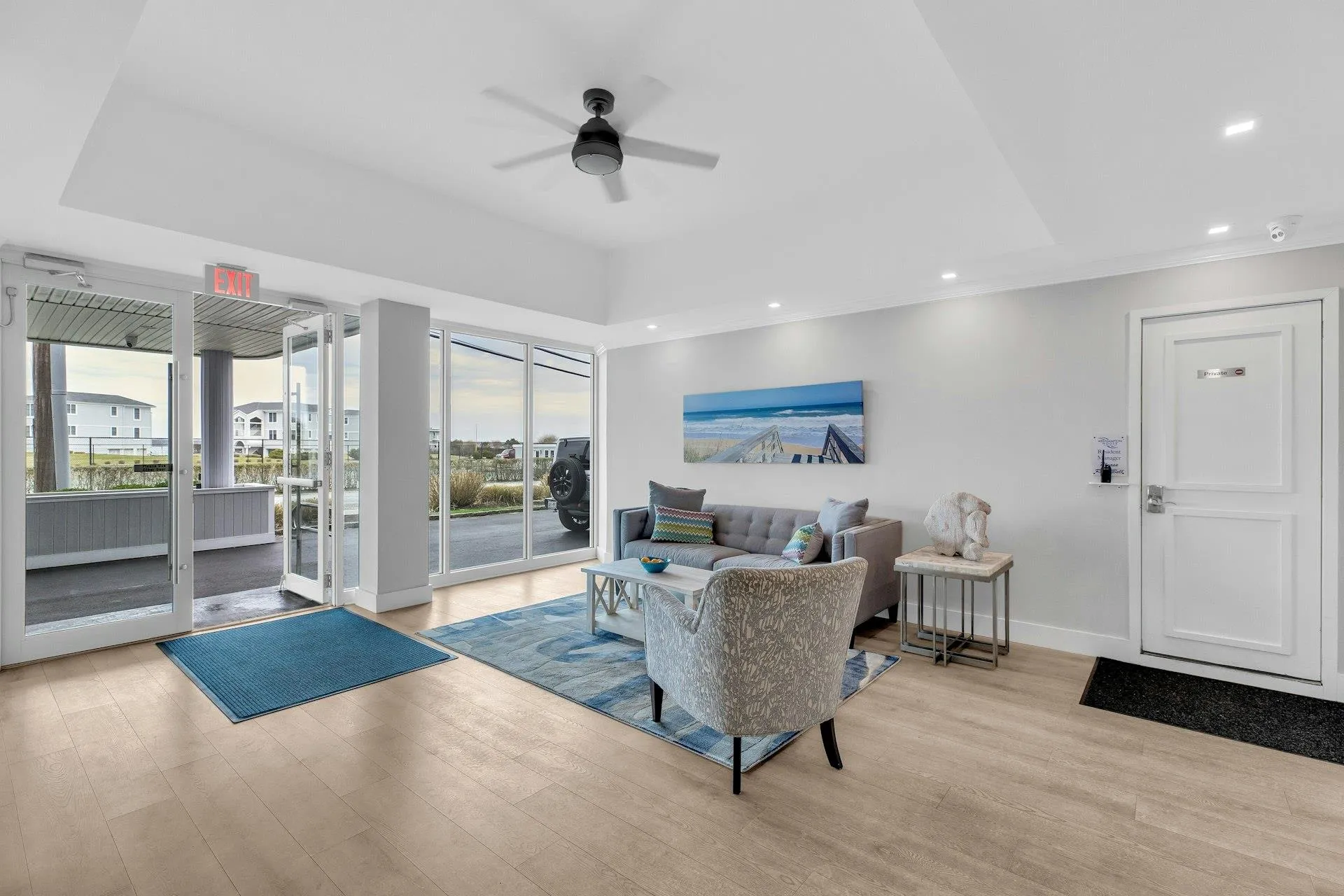 Living room with ceiling fan, a wealth of natural light, and light hardwood / wood-style flooring Living room with ceiling fan, a wealth of natural light, and light hardwood / wood-style flooring