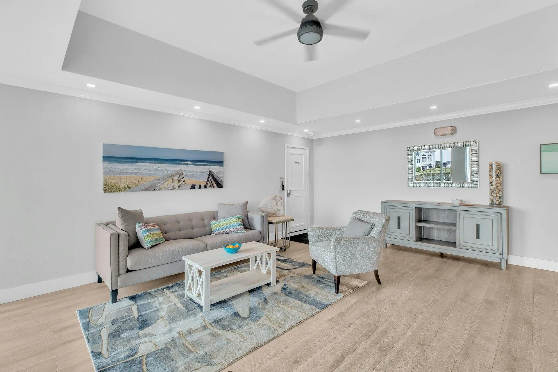 Living room with light wood-type flooring, ceiling fan, and crown molding Living room with light wood-type flooring, ceiling fan, and crown molding