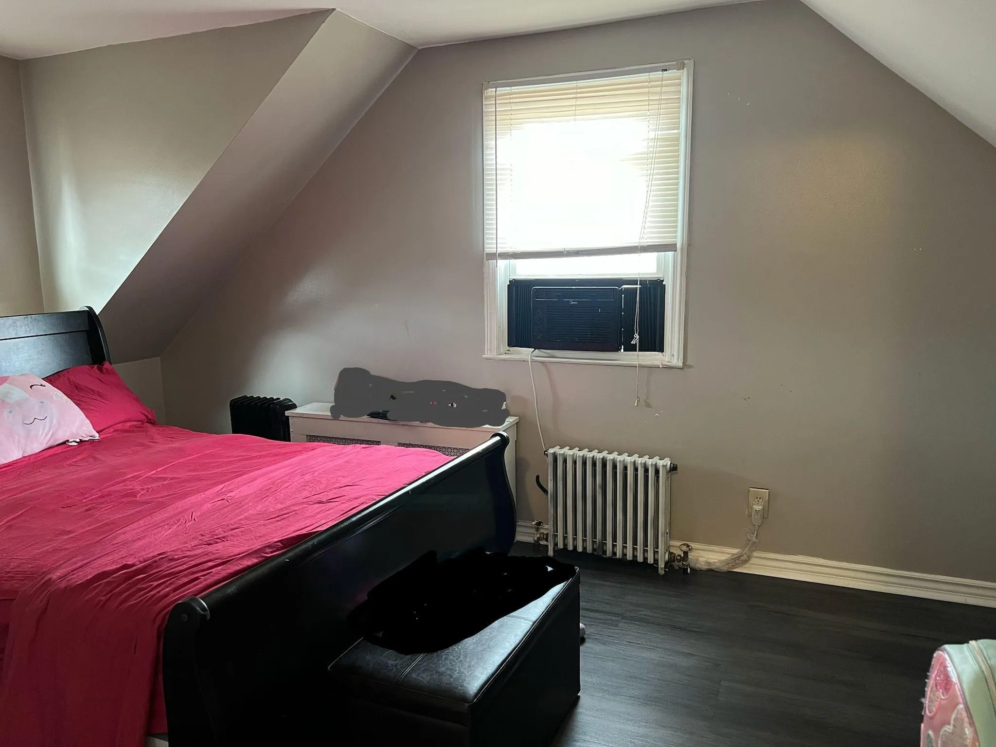 Bedroom featuring dark wood finished floors, radiator, and lofted ceiling Bedroom featuring dark wood finished floors, radiator, and lofted ceiling