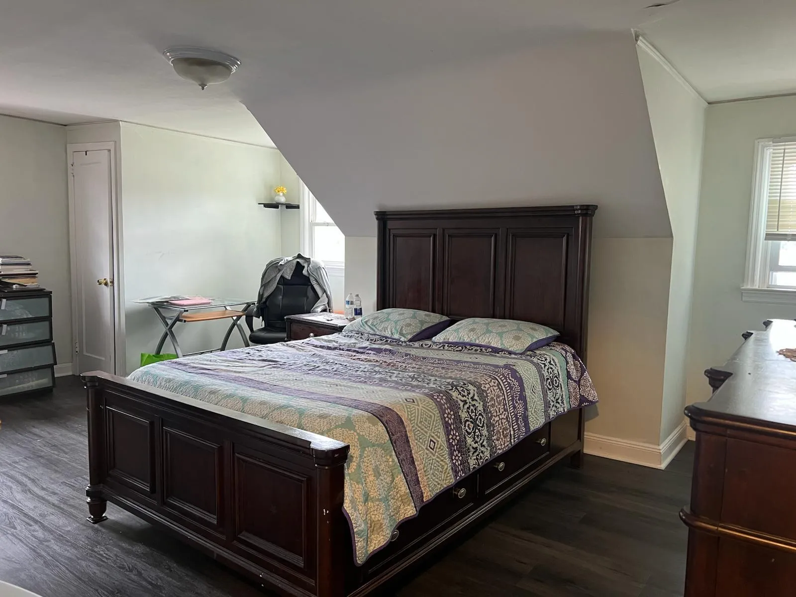 Bedroom featuring dark wood-style flooring, vaulted ceiling, and multiple windows Bedroom featuring dark wood-style flooring, vaulted ceiling, and multiple windows