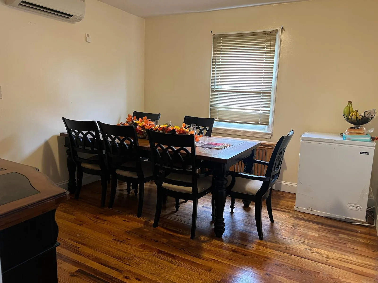 Dining area featuring dark wood finished floors and a wall mounted AC Dining area featuring dark wood finished floors and a wall mounted AC