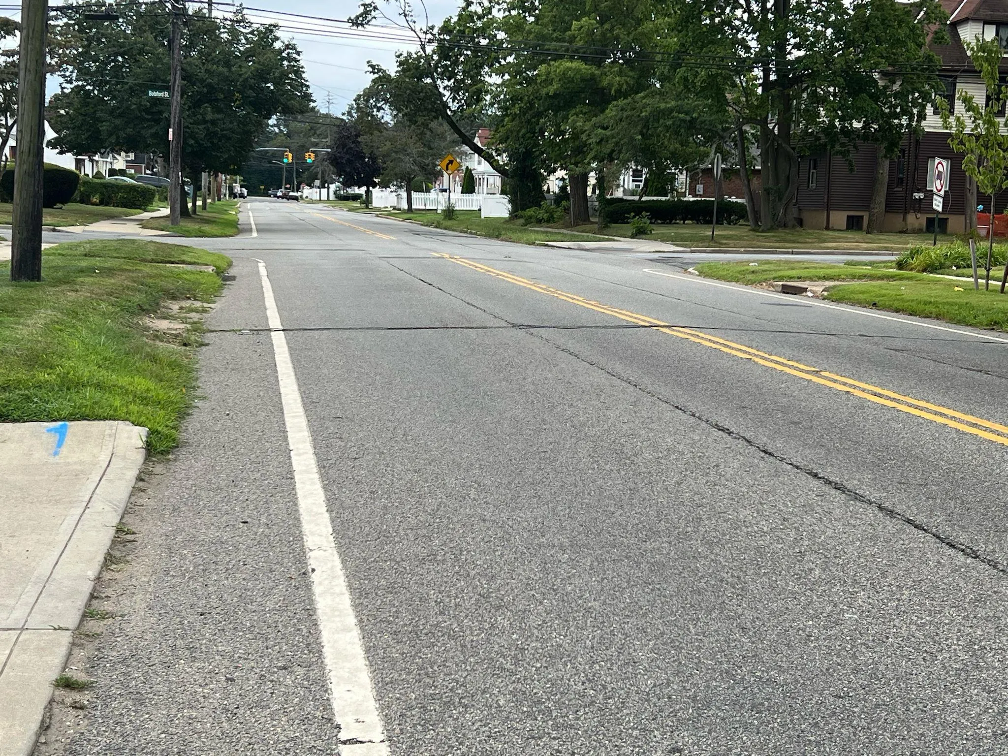 View of asphalt road featuring traffic signs and sidewalks View of asphalt road featuring traffic signs and sidewalks