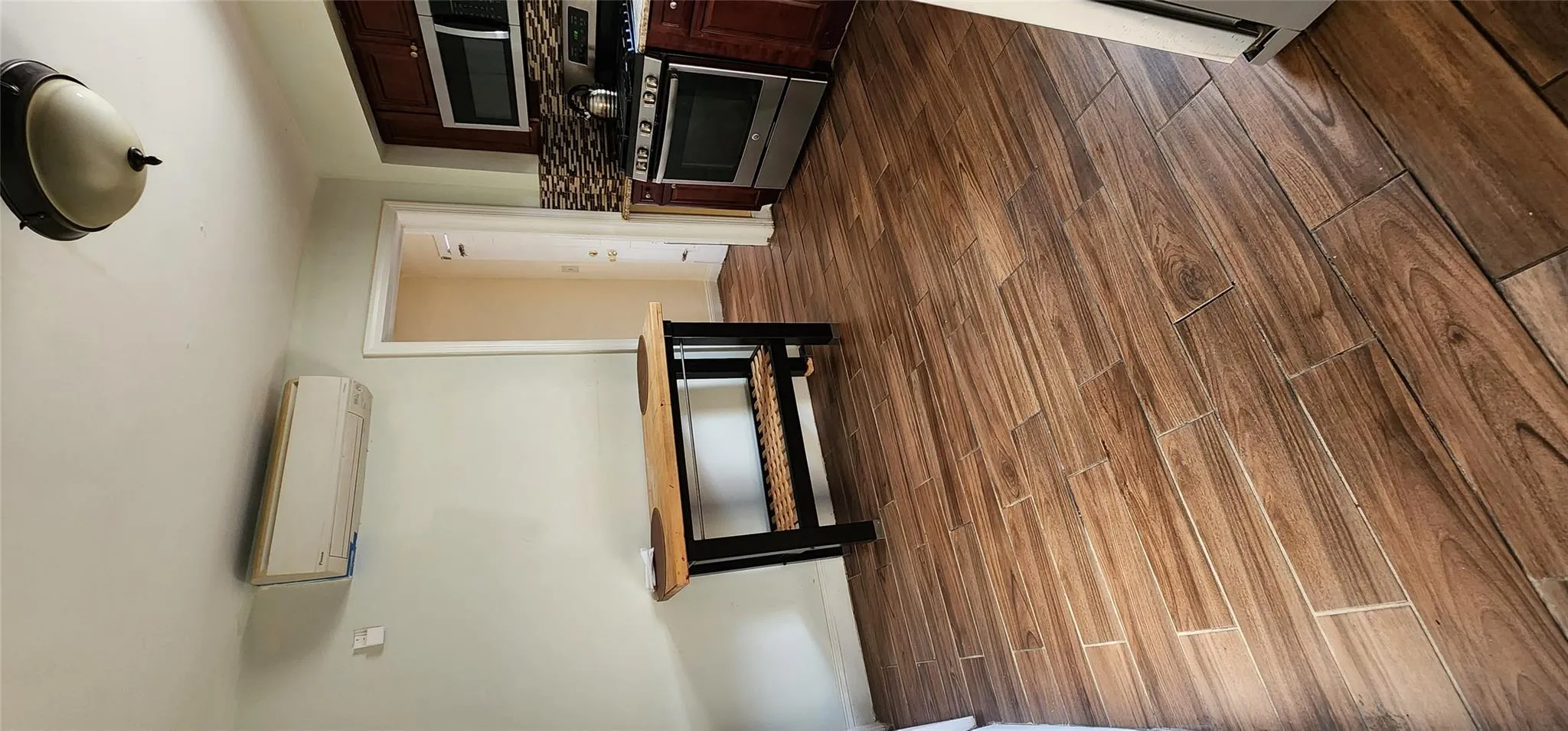 Unfurnished dining area featuring dark wood-type flooring and a wall mounted air conditioner Unfurnished dining area featuring dark wood-type flooring and a wall mounted air conditioner