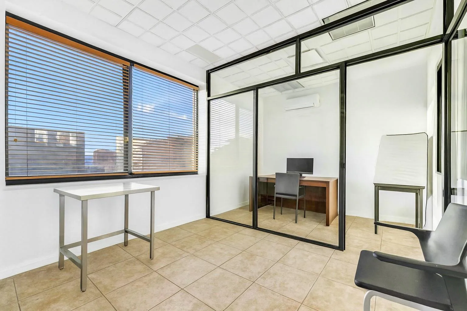 Office space with a wall unit AC and light tile patterned flooring Office space with a wall unit AC and light tile patterned flooring