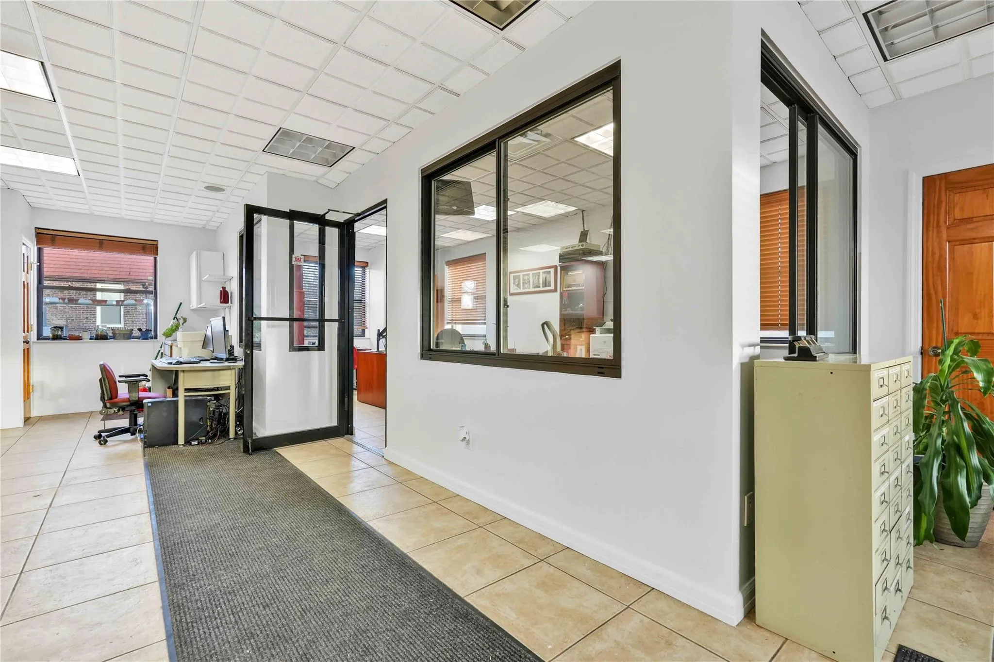 Hall with light tile patterned floors and a drop ceiling Hall with light tile patterned floors and a drop ceiling