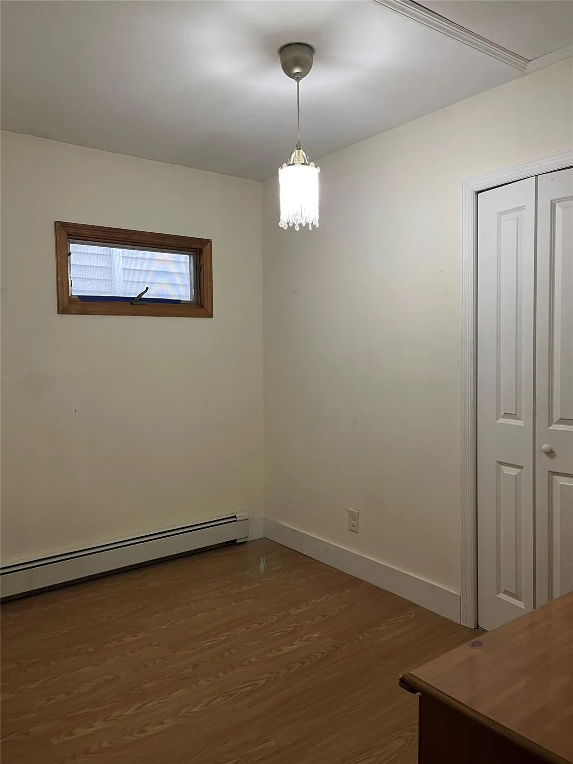 Empty room featuring dark hardwood / wood-style flooring and a baseboard heating unit Empty room featuring dark hardwood / wood-style flooring and a baseboard heating unit