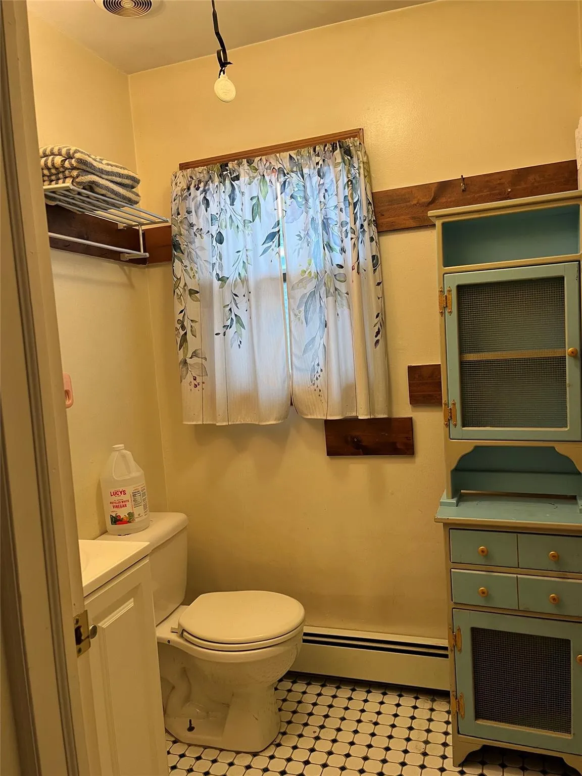 Bathroom with baseboard heating, vanity, and toilet Bathroom with baseboard heating, vanity, and toilet
