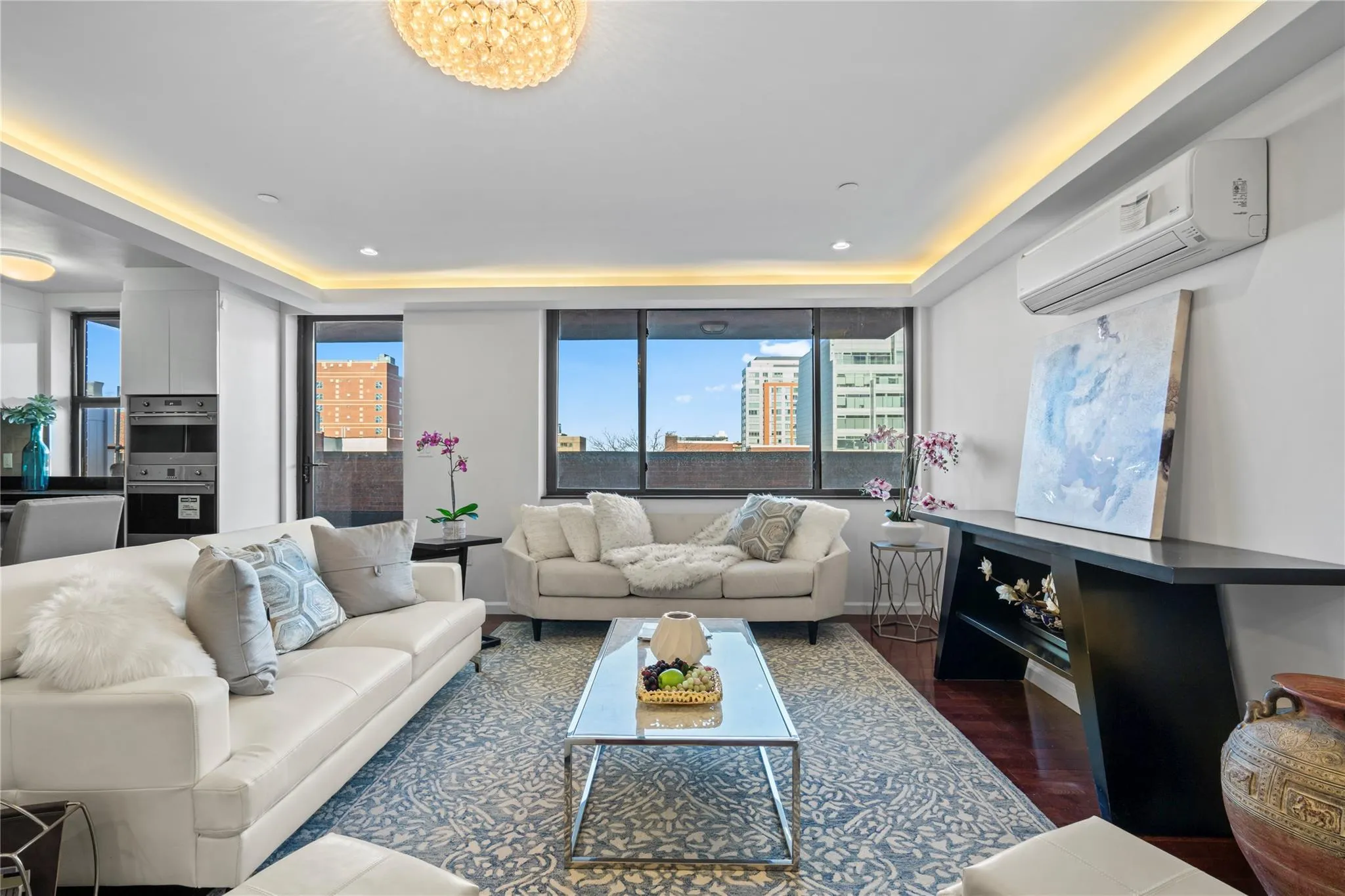 Living room with dark hardwood / wood-style floors, an inviting chandelier, and a wall mounted AC Living room with dark hardwood / wood-style floors, an inviting chandelier, and a wall mounted AC