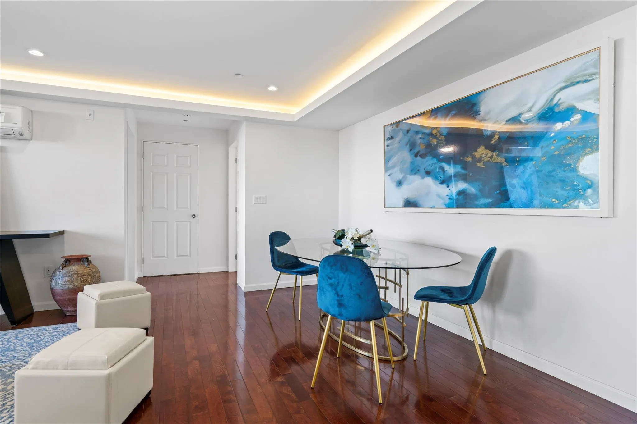 Dining area featuring a raised ceiling, dark wood-type flooring, and a wall unit AC Dining area featuring a raised ceiling, dark wood-type flooring, and a wall unit AC