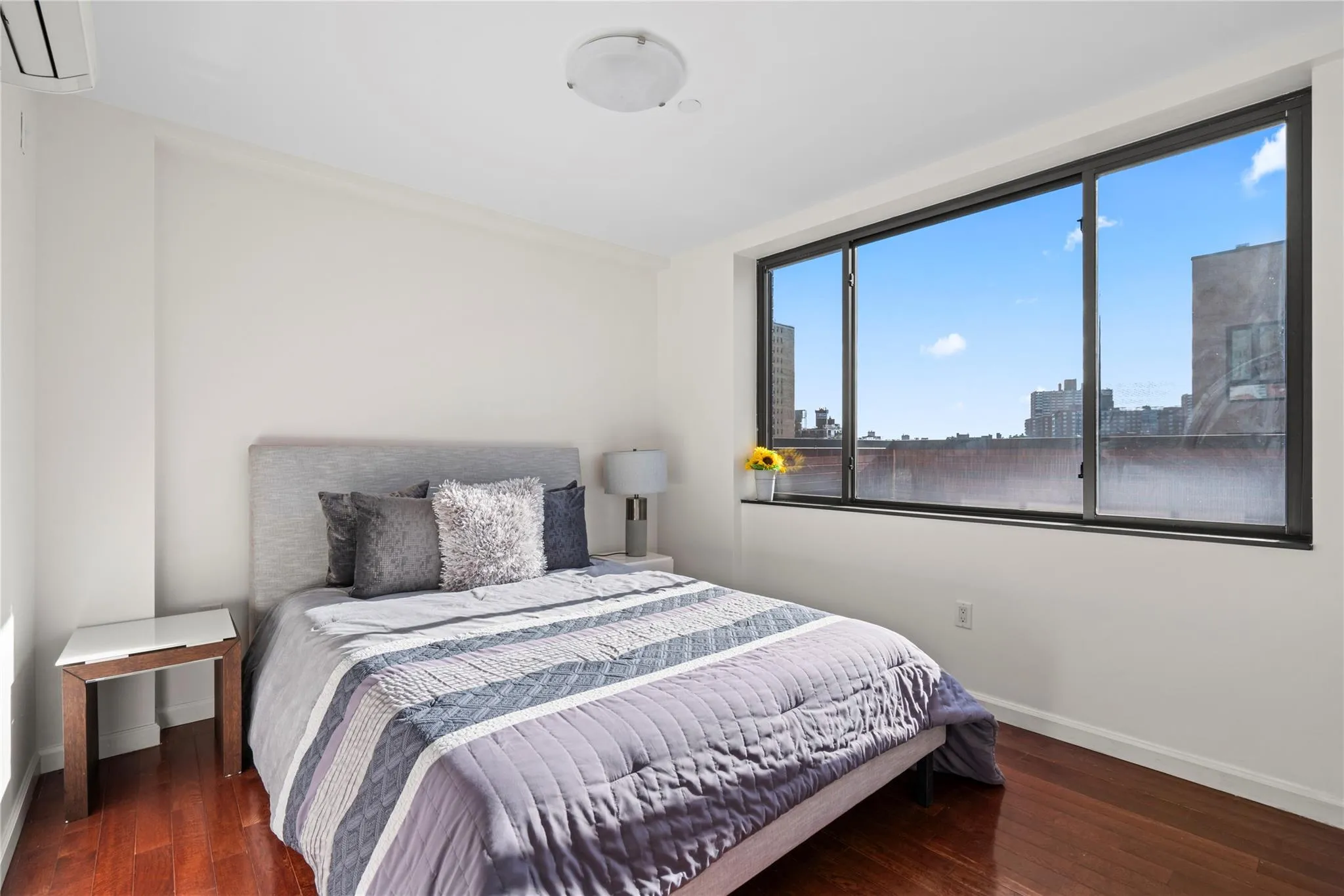 Bedroom with dark hardwood / wood-style flooring and a wall unit AC Bedroom with dark hardwood / wood-style flooring and a wall unit AC