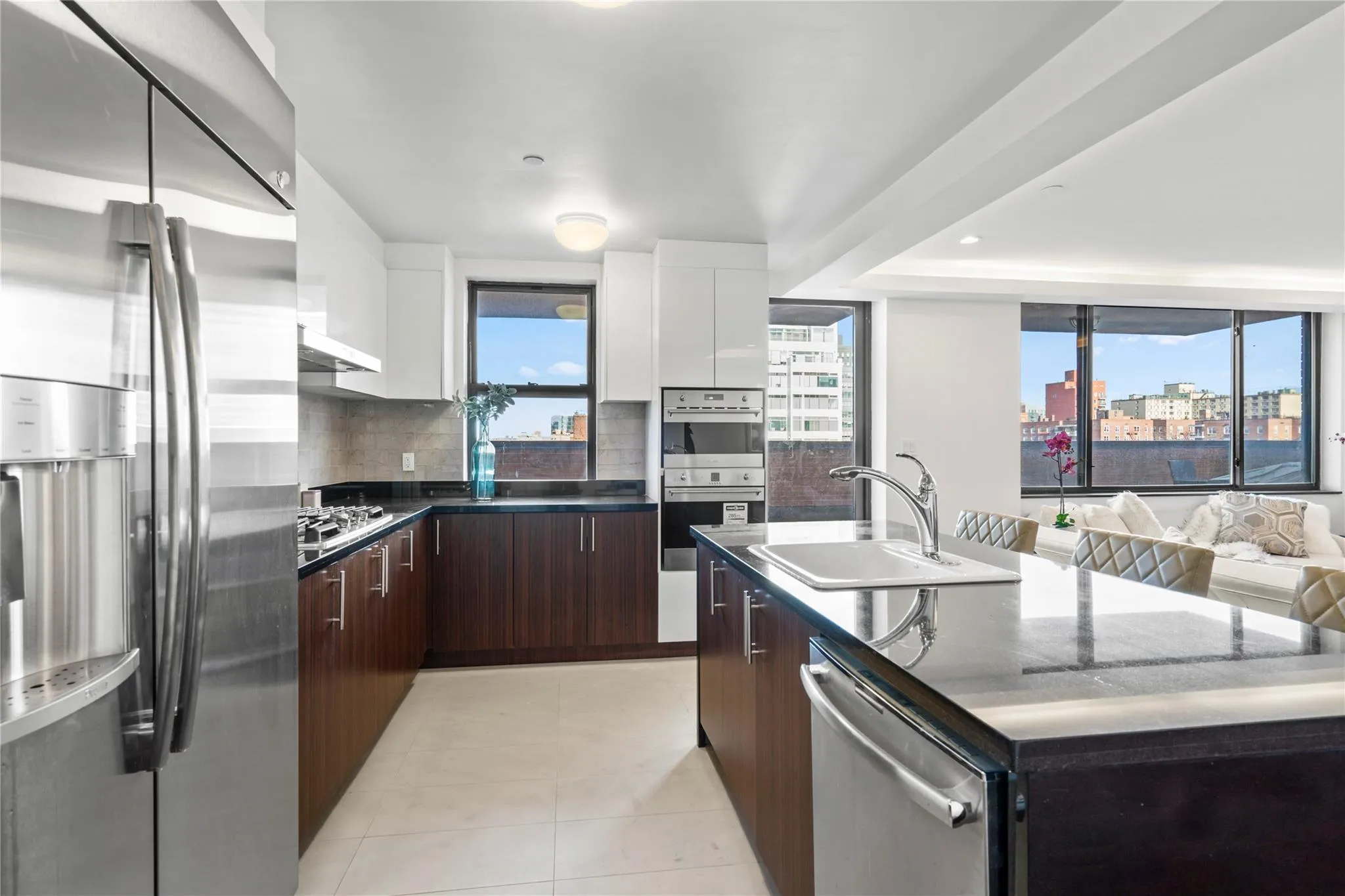 Kitchen featuring white cabinets, backsplash, stainless steel appliances, and an island with sink Kitchen featuring white cabinets, backsplash, stainless steel appliances, and an island with sink