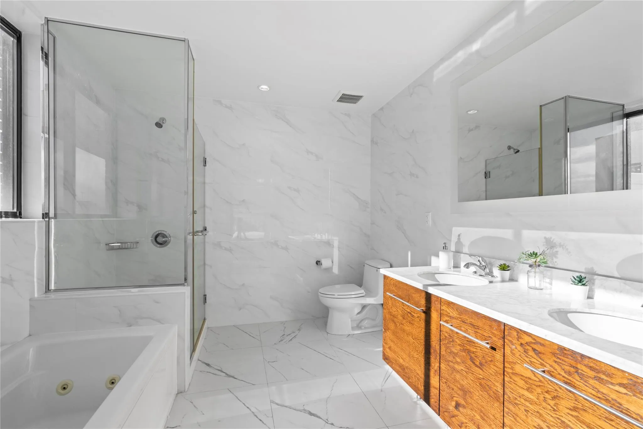 Full bathroom featuring vanity, separate shower and tub, toilet, and tile walls Full bathroom featuring vanity, separate shower and tub, toilet, and tile walls