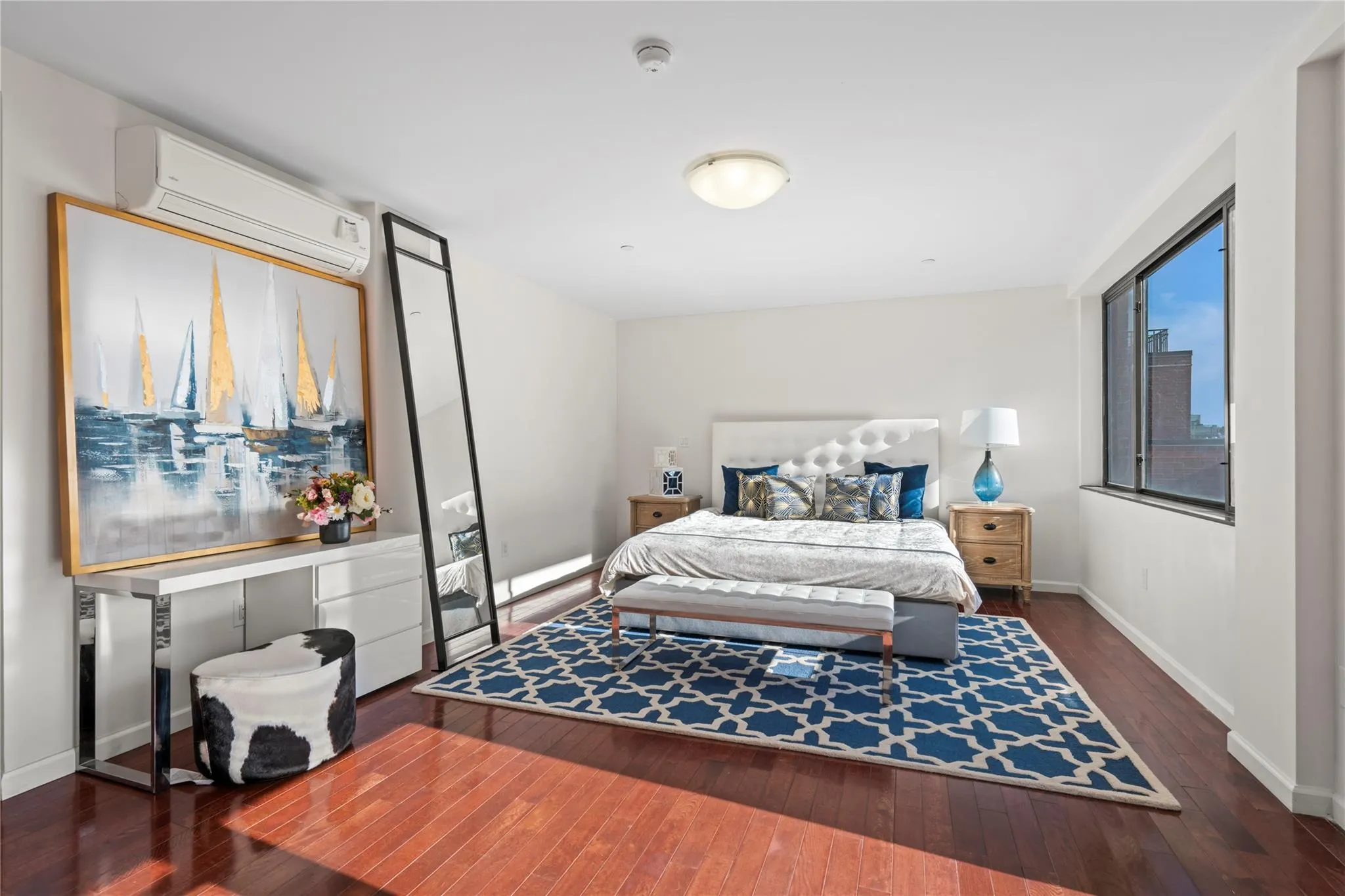 Bedroom featuring a wall mounted air conditioner and dark hardwood / wood-style flooring Bedroom featuring a wall mounted air conditioner and dark hardwood / wood-style flooring