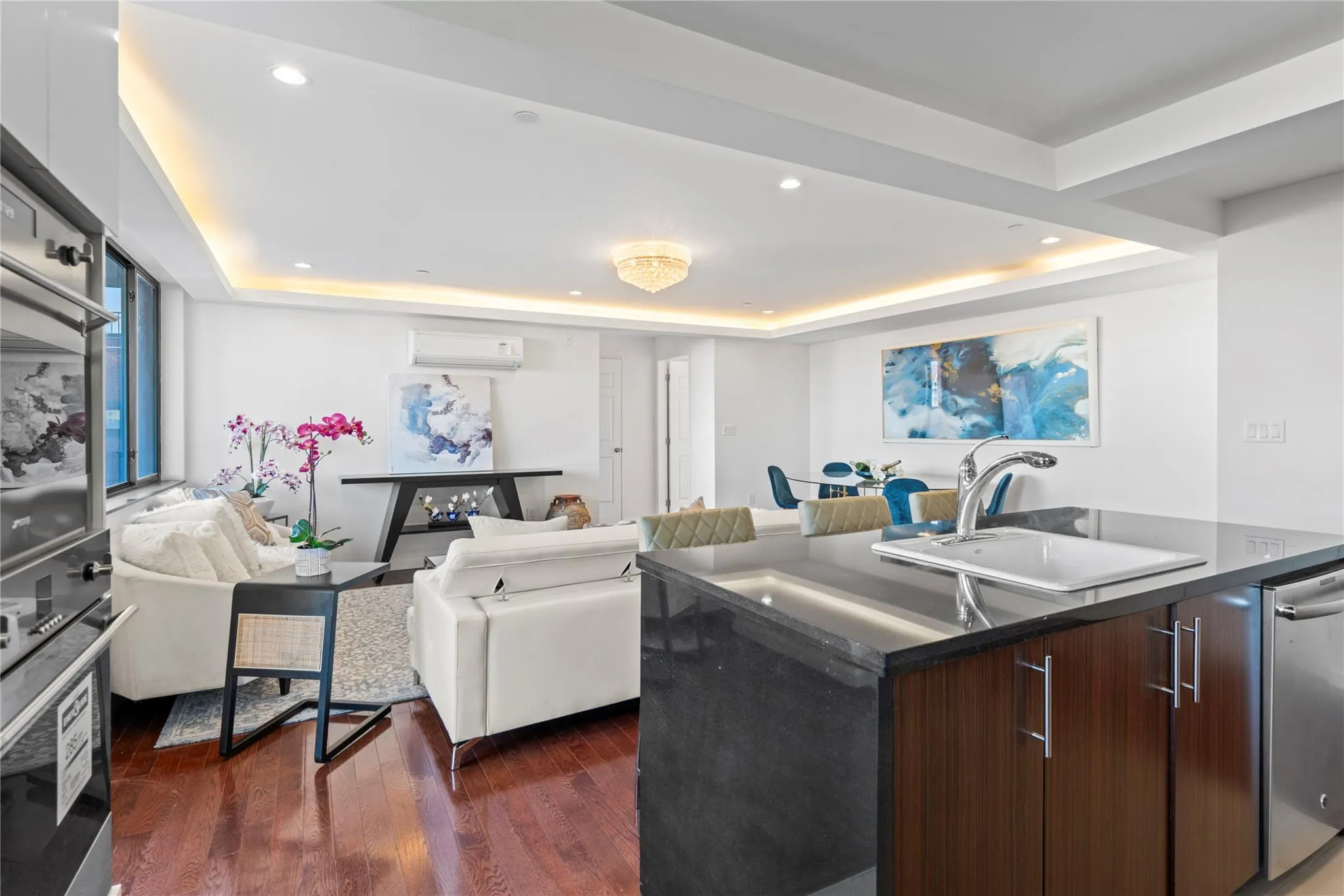 Kitchen featuring a tray ceiling, dark brown cabinetry, a center island, and stainless steel dishwasher Kitchen featuring a tray ceiling, dark brown cabinetry, a center island, and stainless steel dishwasher