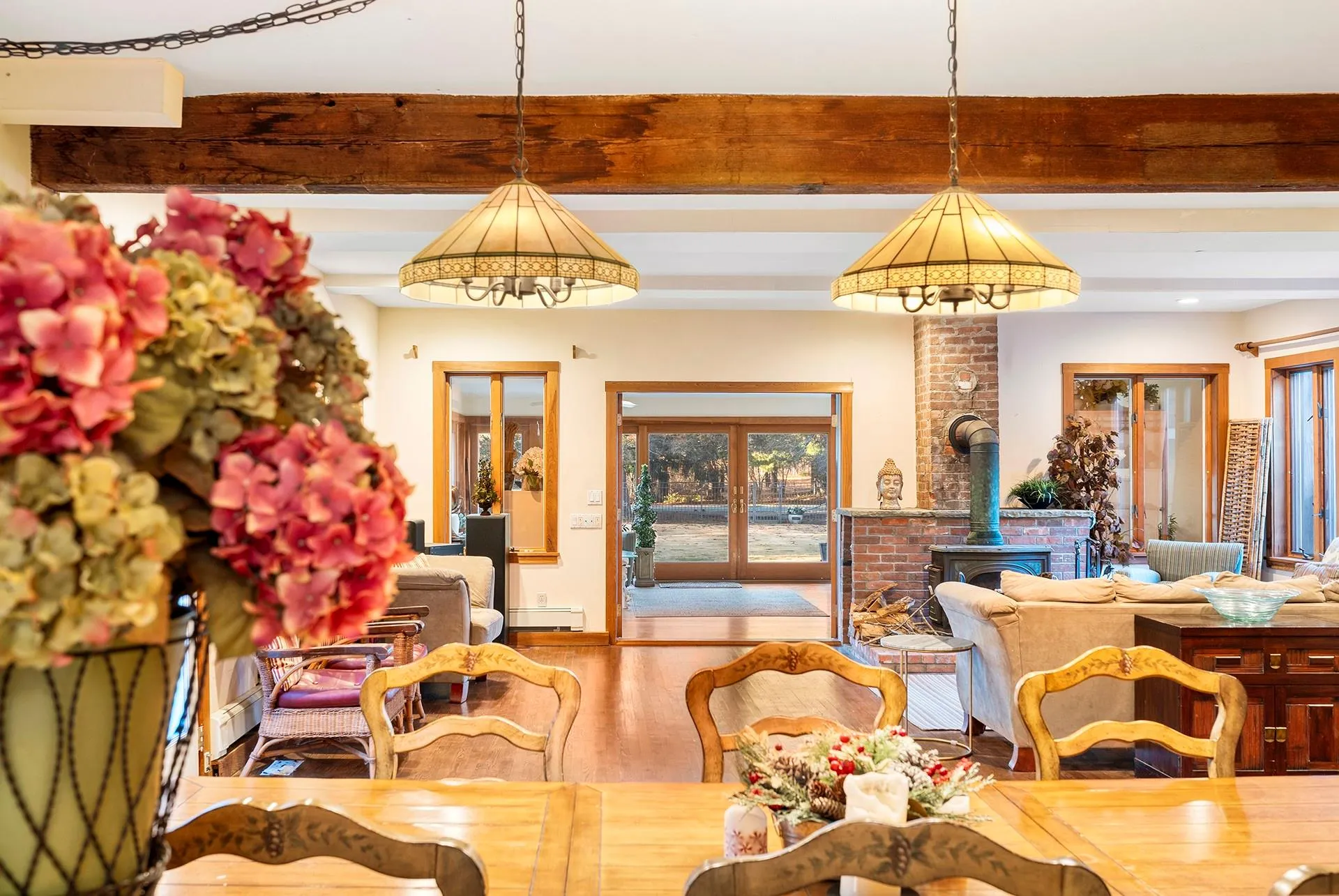 Dining room with a wood stove, wood finished floors, and french doors Dining room with a wood stove, wood finished floors, and french doors