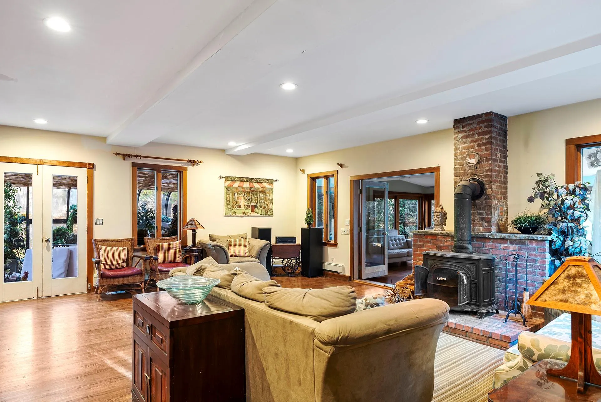 Living area featuring french doors, beamed ceiling, a wood stove, healthy amount of natural light, and recessed lighting Living area featuring french doors, beamed ceiling, a wood stove, healthy amount of natural light, and recessed lighting