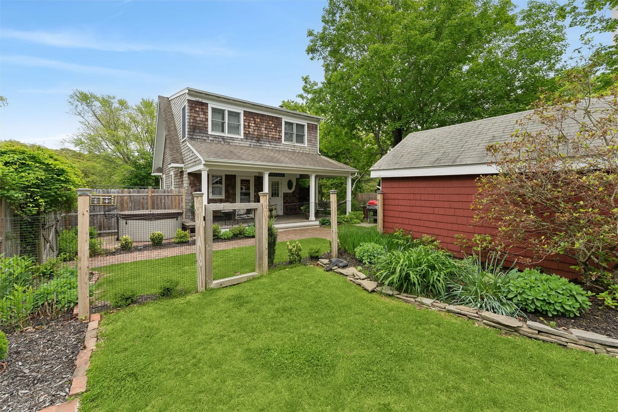 Shingle-style home with a porch and a shingled roof Shingle-style home with a porch and a shingled roof