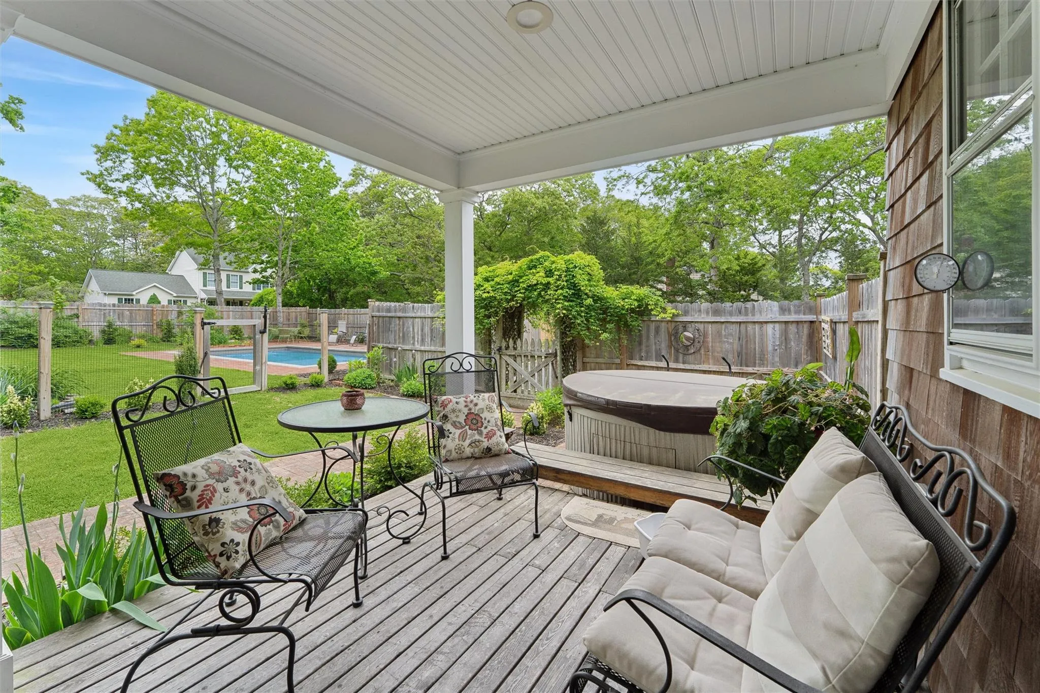 Fenced backyard with a covered hot tub and a wooden deck Fenced backyard with a covered hot tub and a wooden deck