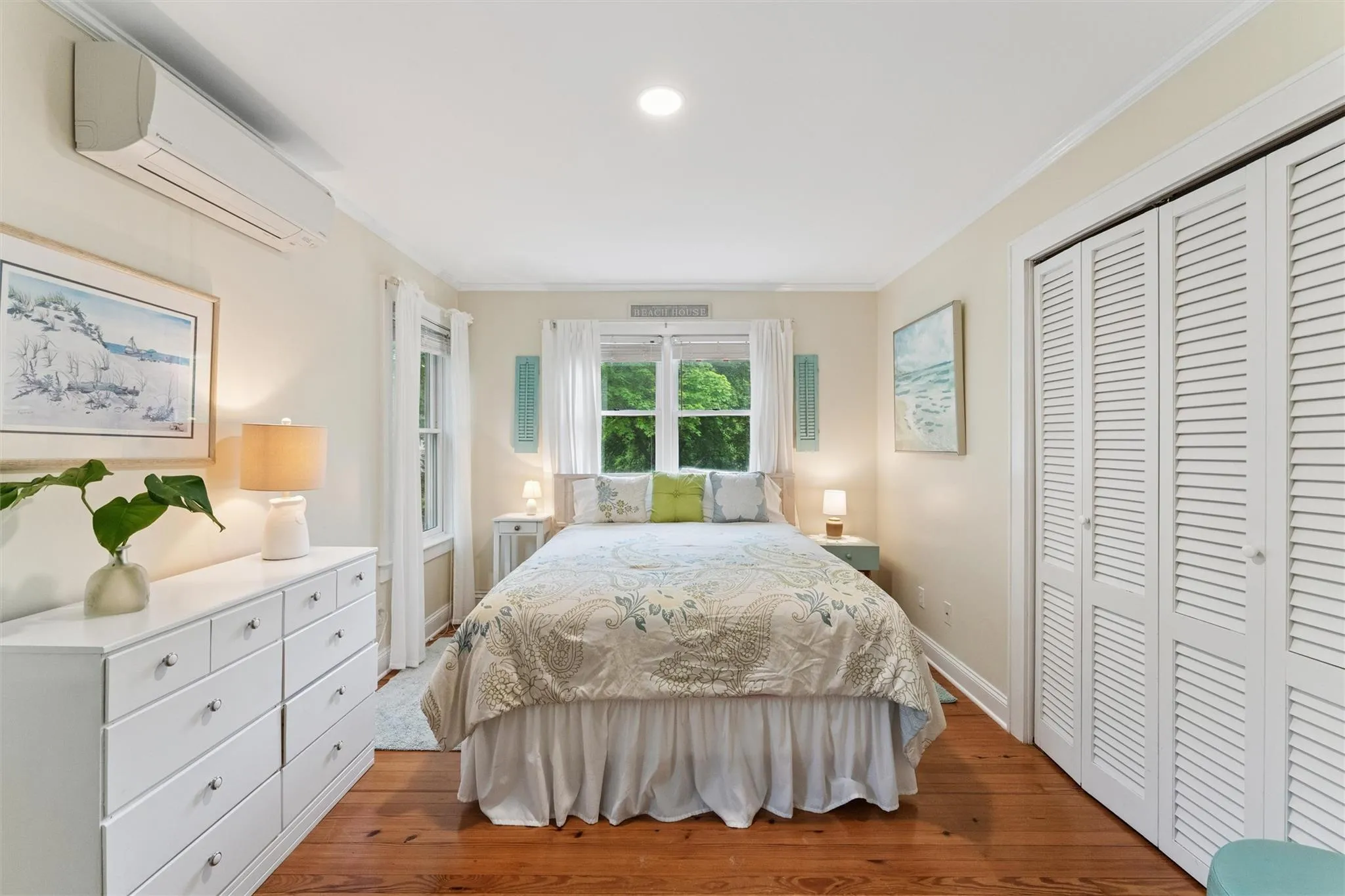 Bedroom with an AC wall unit, wood finished floors, a closet, recessed lighting, and crown molding Bedroom with an AC wall unit, wood finished floors, a closet, recessed lighting, and crown molding