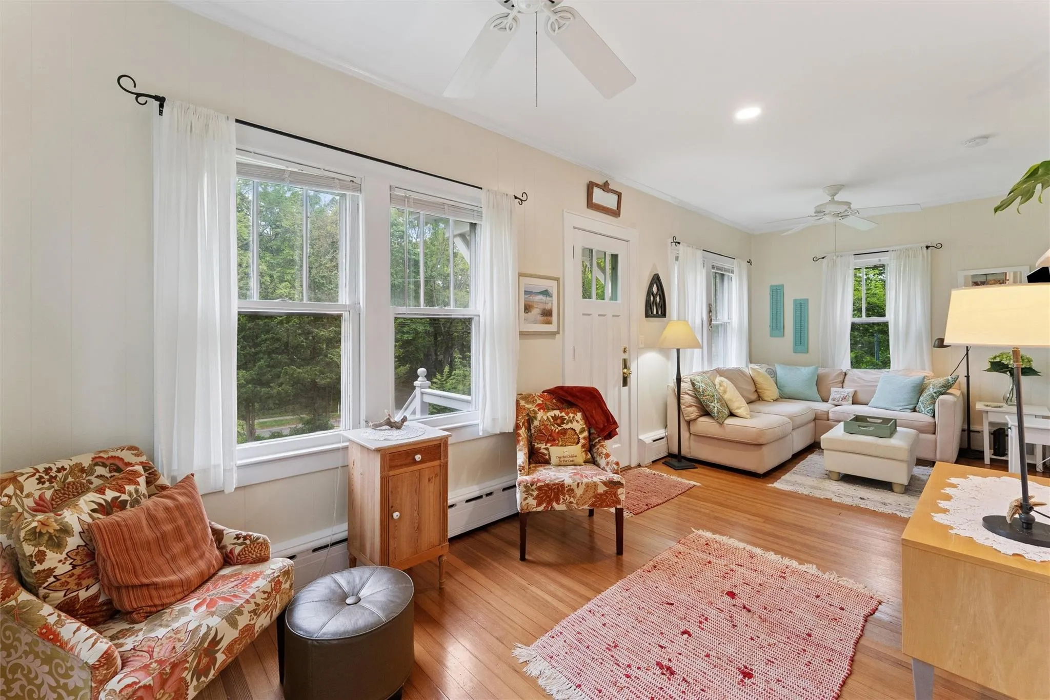 Living area with a baseboard radiator, ceiling fan, light wood-style floors, baseboard heating, and ornamental molding Living area with a baseboard radiator, ceiling fan, light wood-style floors, baseboard heating, and ornamental molding