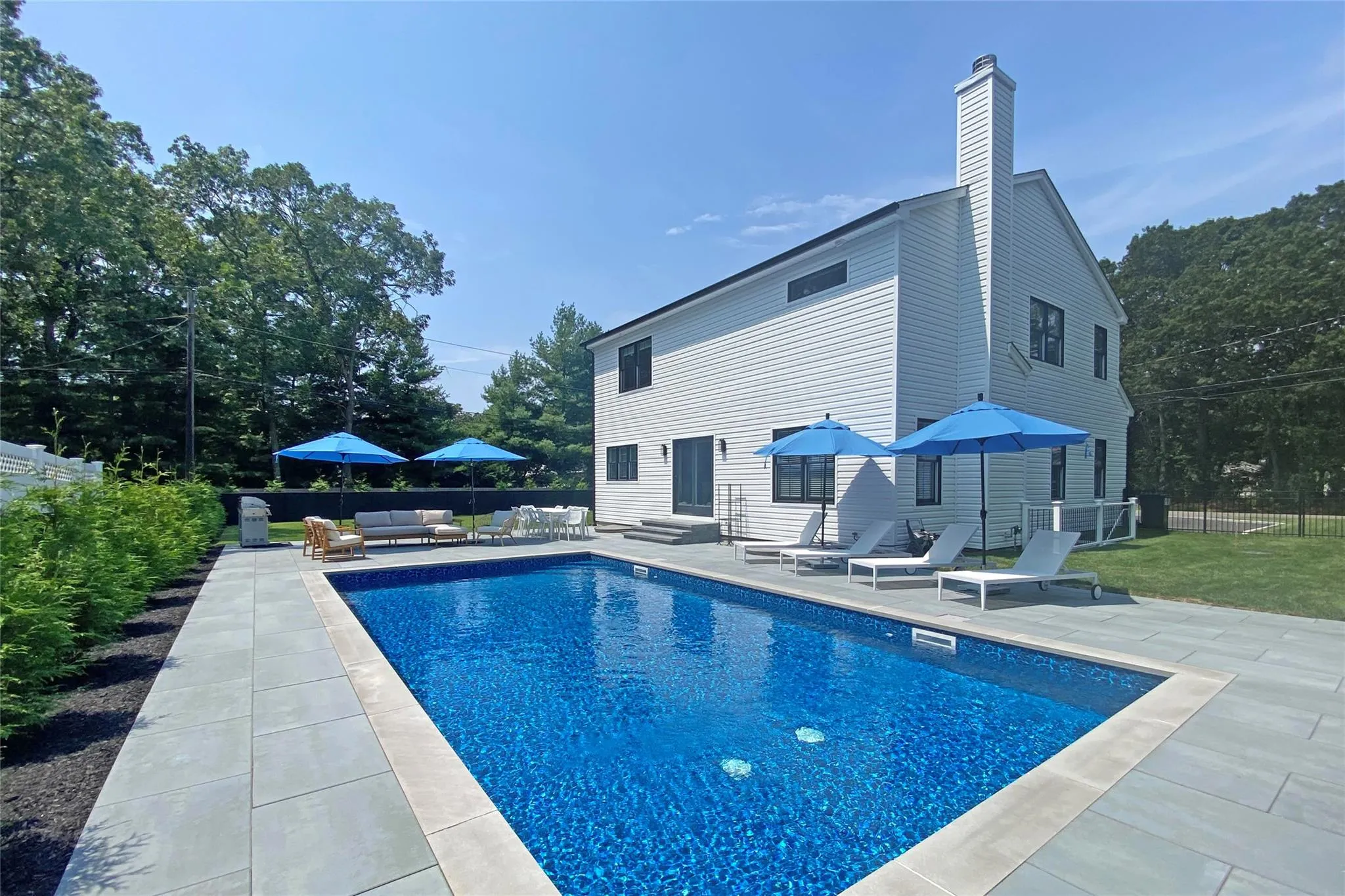 View of pool featuring a patio area, an outdoor living space, view of scattered trees, and entry steps View of pool featuring a patio area, an outdoor living space, view of scattered trees, and entry steps