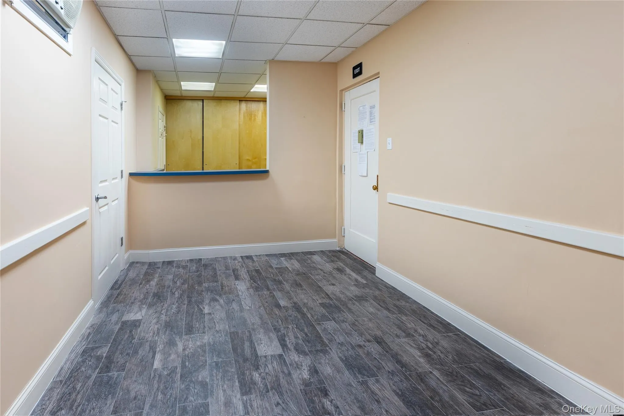 Spare room with a paneled ceiling and dark hardwood / wood-style floors Spare room with a paneled ceiling and dark hardwood / wood-style floors