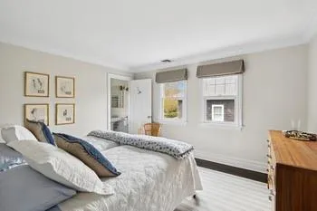 Bedroom featuring connected bathroom, crown molding, and light hardwood / wood-style floors
