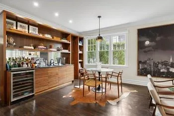 Bar featuring ornamental molding, decorative light fixtures, beverage cooler, and dark wood-type flooring