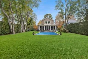 Back of house with a fenced in pool and a lawn