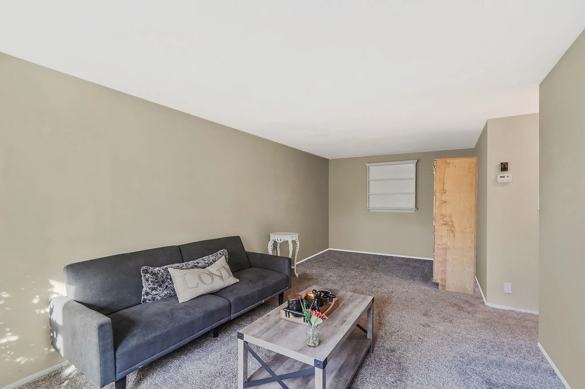 Carpeted living area featuring baseboards Carpeted living area featuring baseboards
