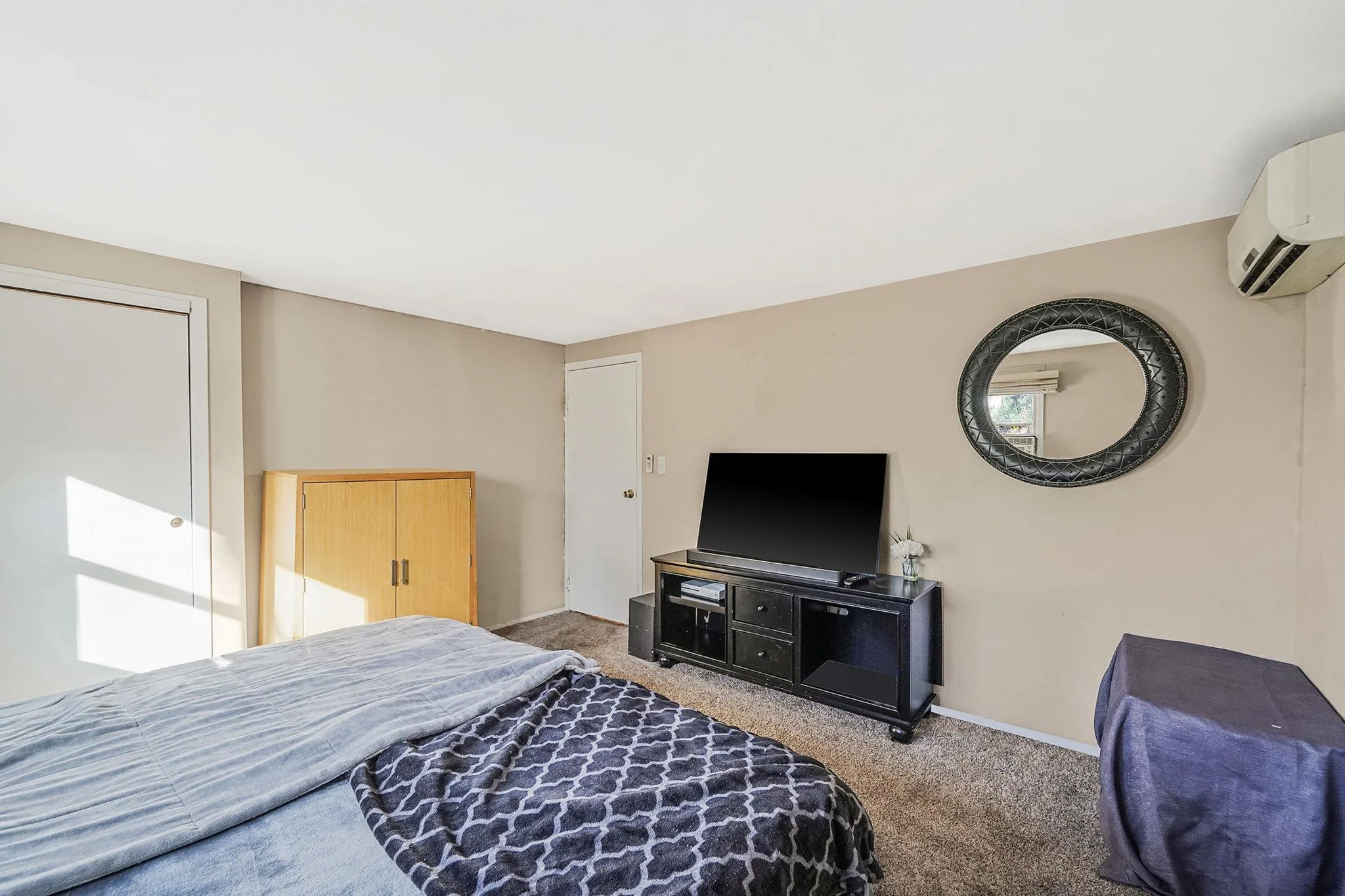 Bedroom featuring carpet and a wall mounted AC Bedroom featuring carpet and a wall mounted AC