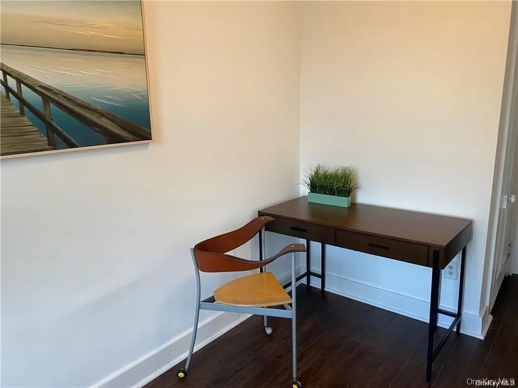 Office space with dark wood-style flooring and baseboards Office space with dark wood-style flooring and baseboards