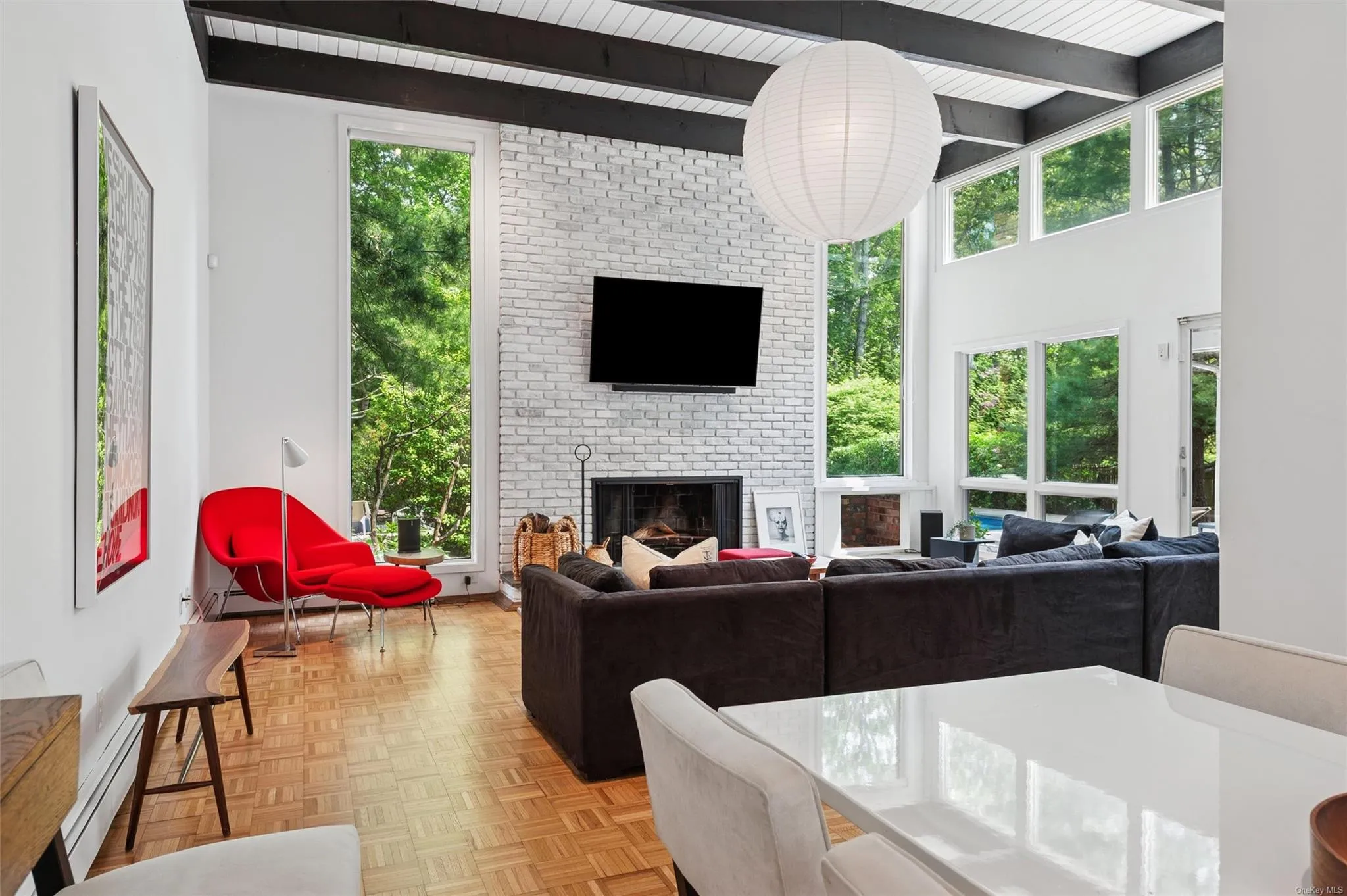 Living area with baseboard heating, beamed ceiling, and a fireplace Living area with baseboard heating, beamed ceiling, and a fireplace