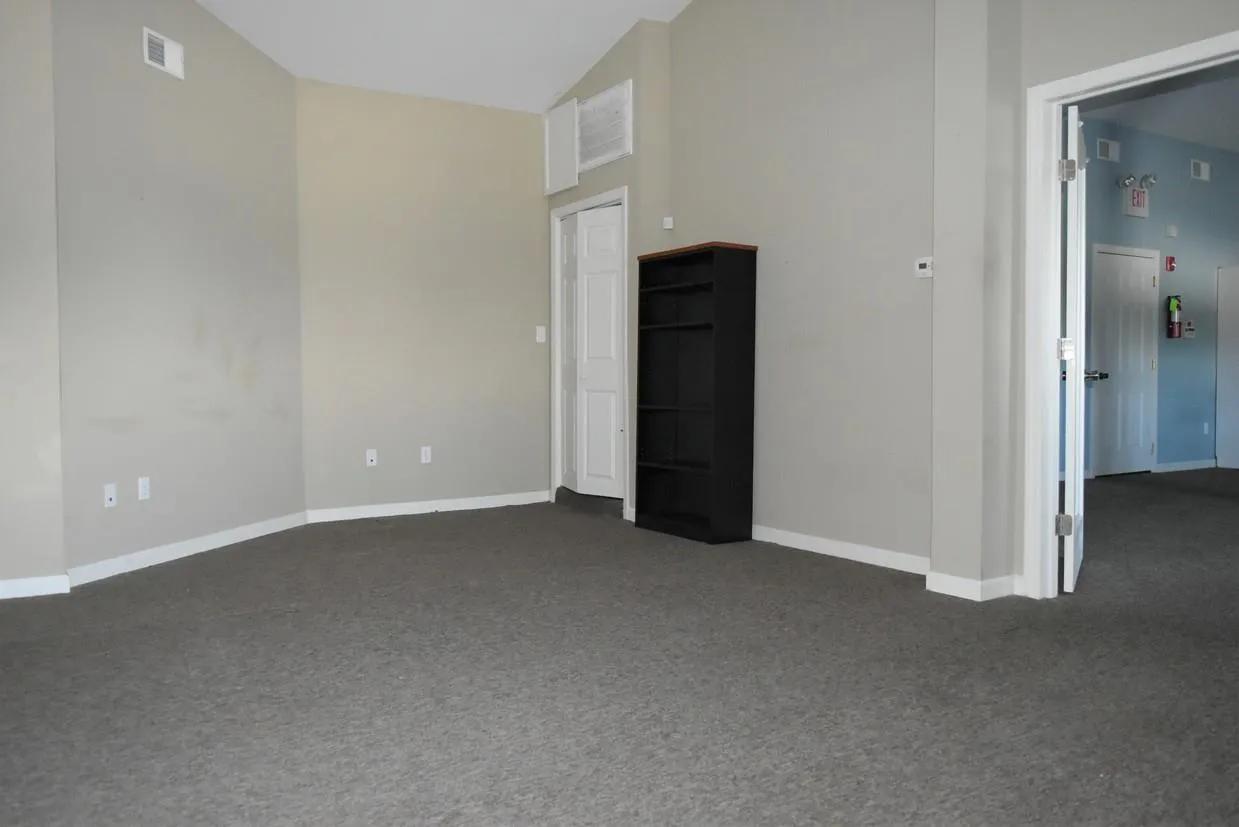 Unfurnished living room with dark carpet and vaulted ceiling Unfurnished living room with dark carpet and vaulted ceiling