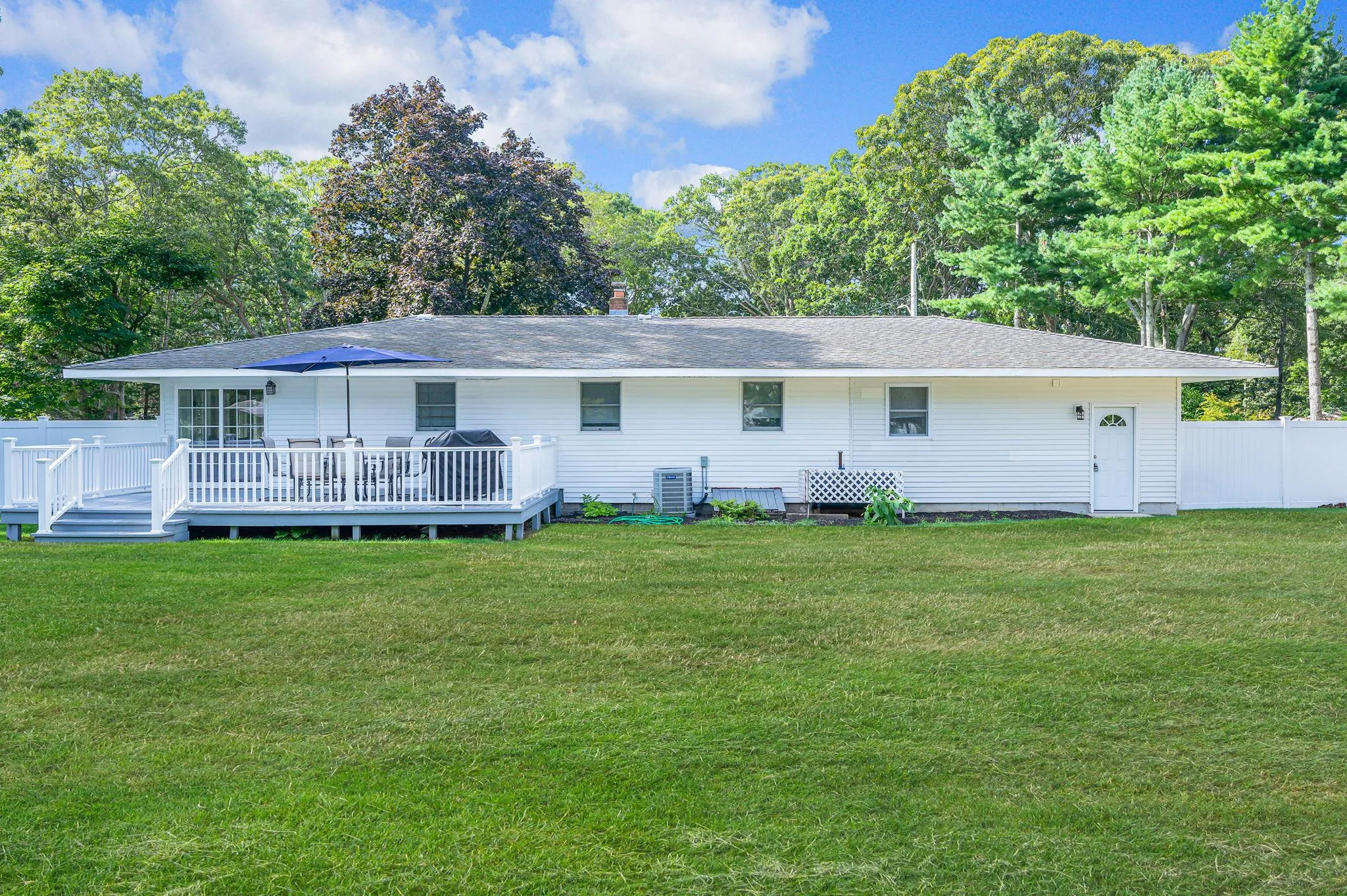 Back of property with roof with shingles, a chimney, view of scattered trees, and a deck Back of property with roof with shingles, a chimney, view of scattered trees, and a deck