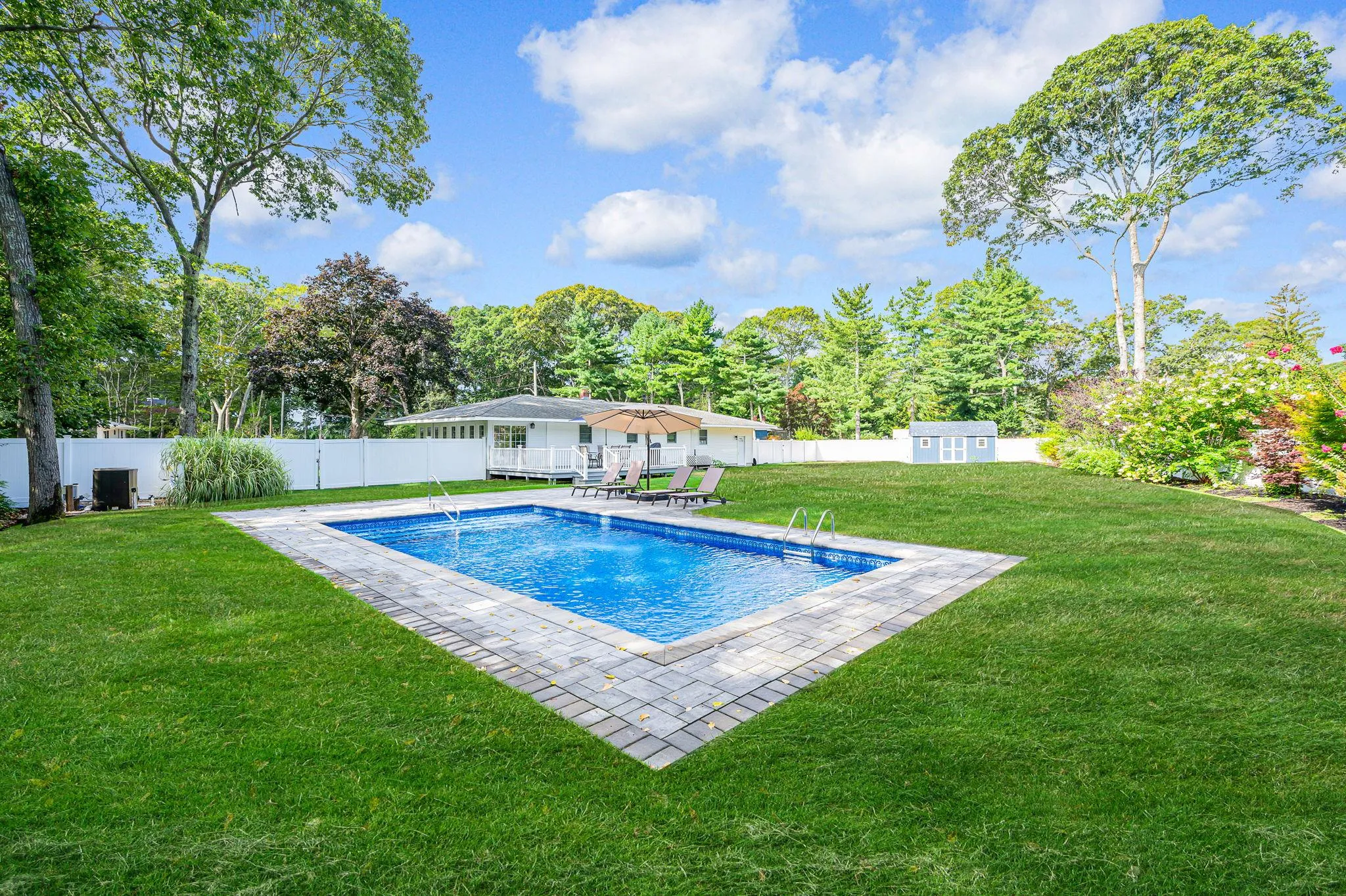 View of swimming pool with a fenced backyard, an outbuilding, a patio area, and view of scattered trees View of swimming pool with a fenced backyard, an outbuilding, a patio area, and view of scattered trees