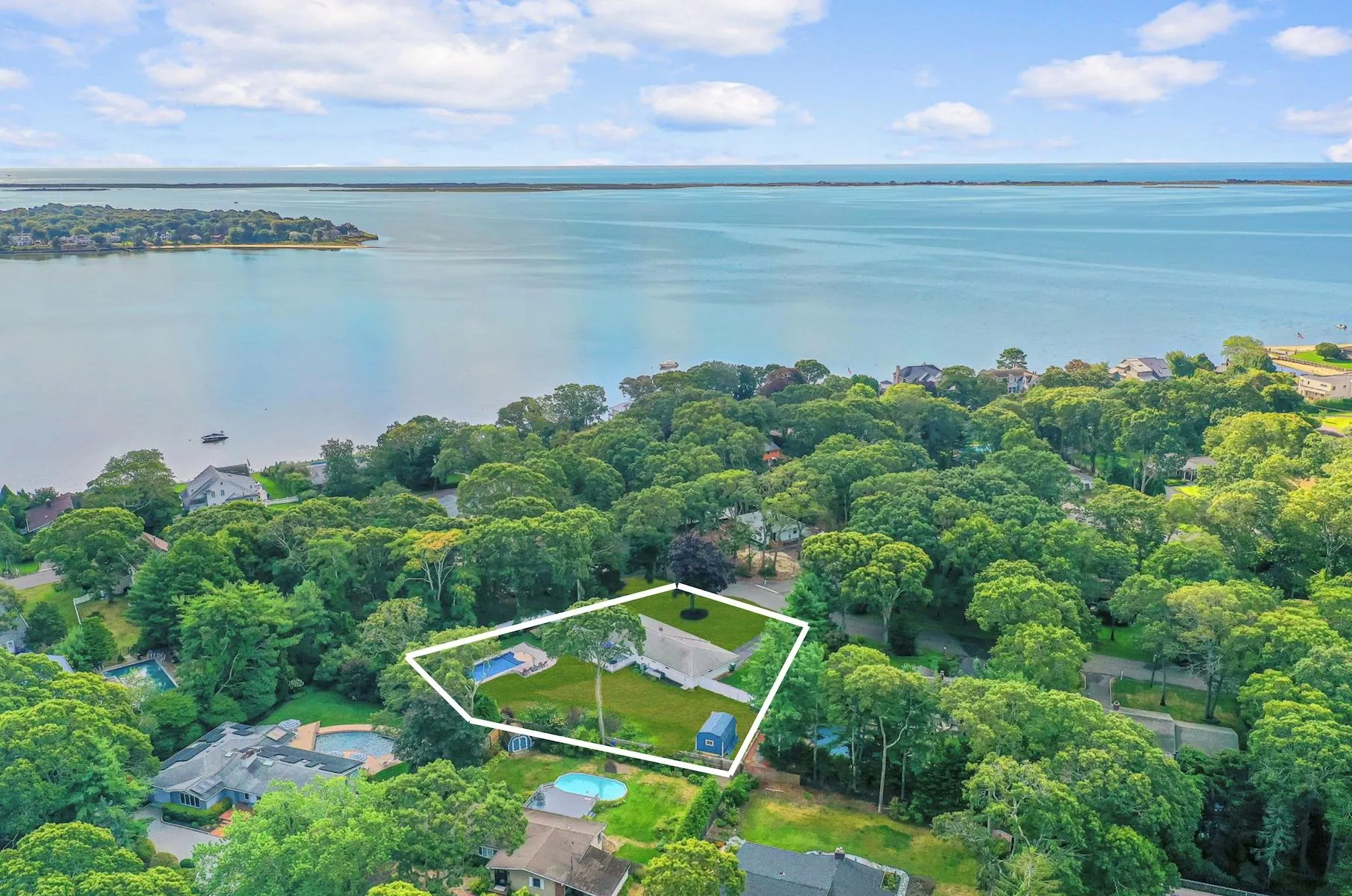 Aerial view of residential area featuring property parcel outlined and a large body of water Aerial view of residential area featuring property parcel outlined and a large body of water