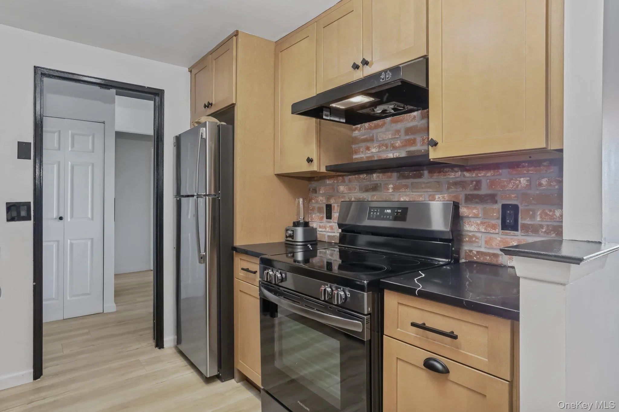 Beautiful new kitchen with oak cabinets, quartz counters, brick backsplash, and new appliances Beautiful new kitchen with oak cabinets, quartz counters, brick backsplash, and new appliances