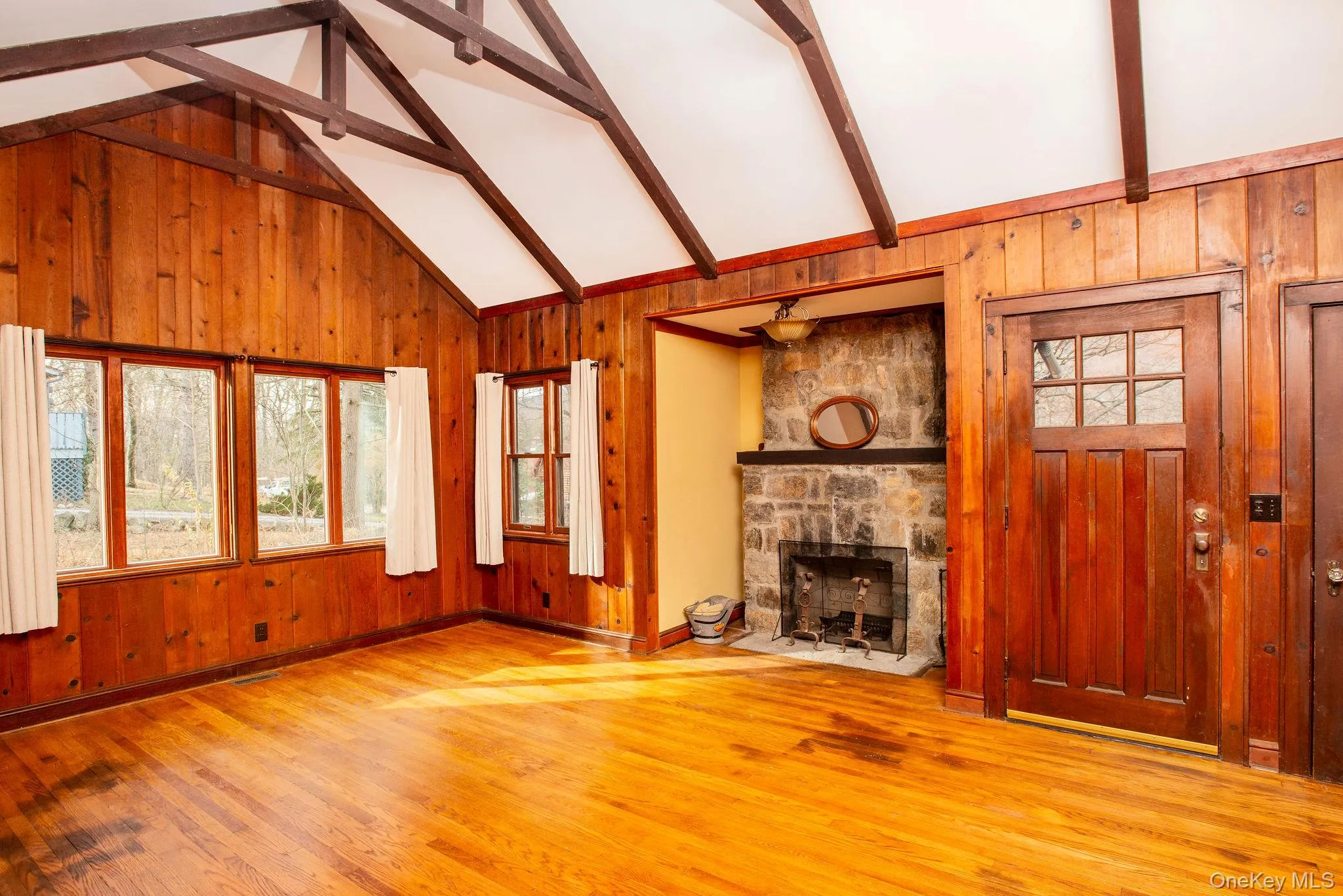 Carefully restored great room, with wood burning fireplace, wood paneling, tall ceilings and beams. Carefully restored great room, with wood burning fireplace, wood paneling, tall ceilings and beams.